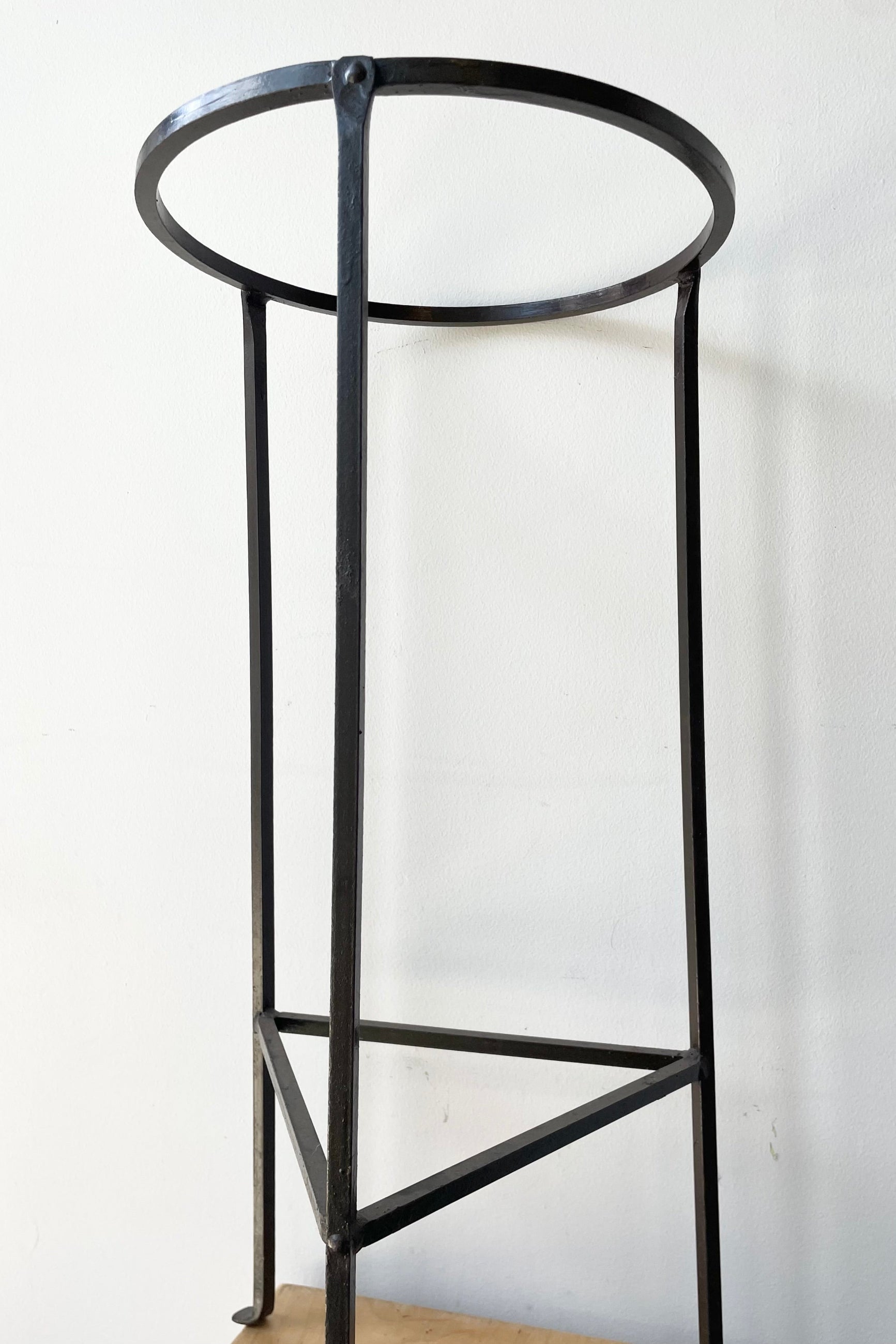 Idetail of the Iron Plant Stand Medium 12" D x 26.5" H against a white wall ©Sprout Home