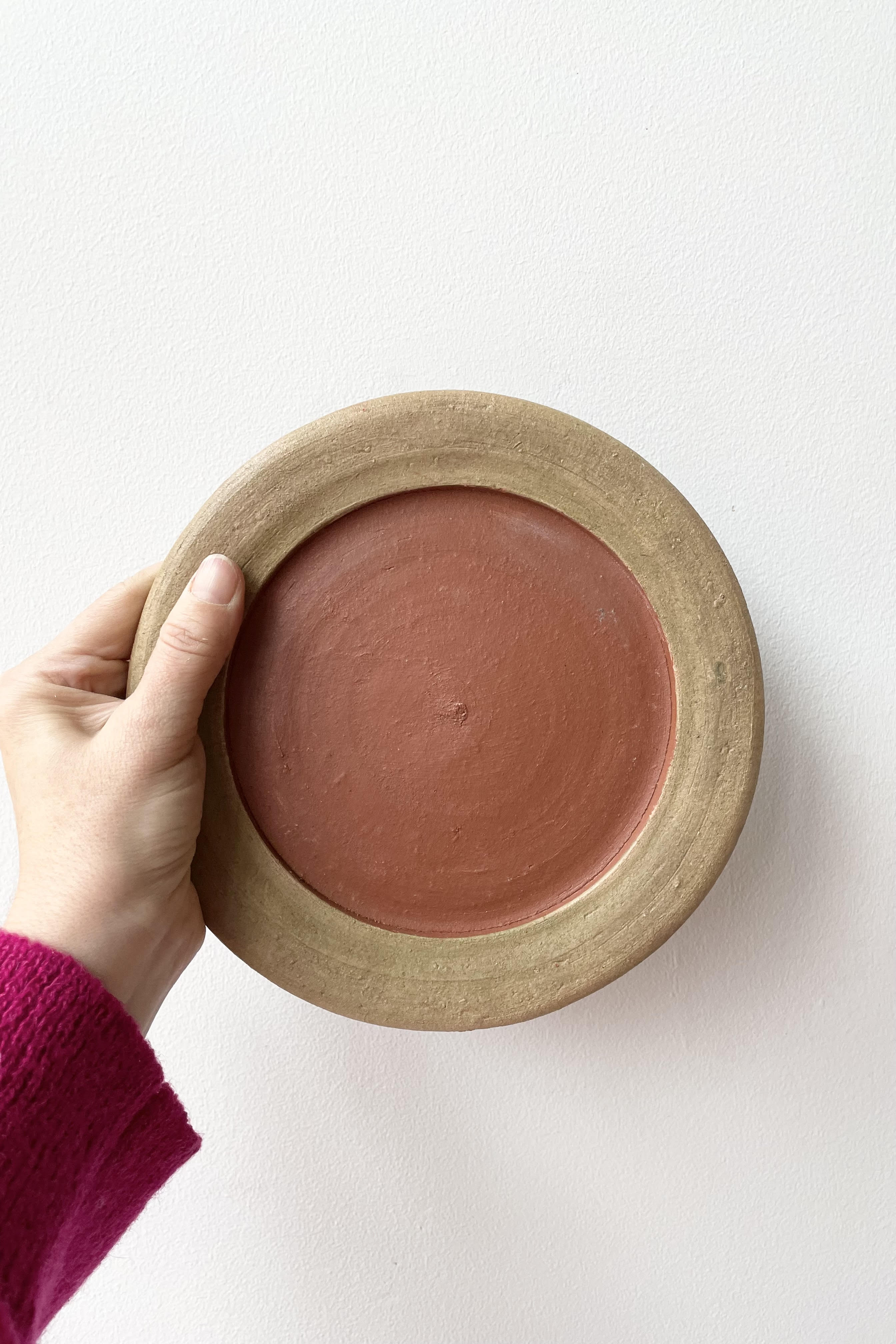 A hand holds the Aged Saucer #3 against a white backdrop.