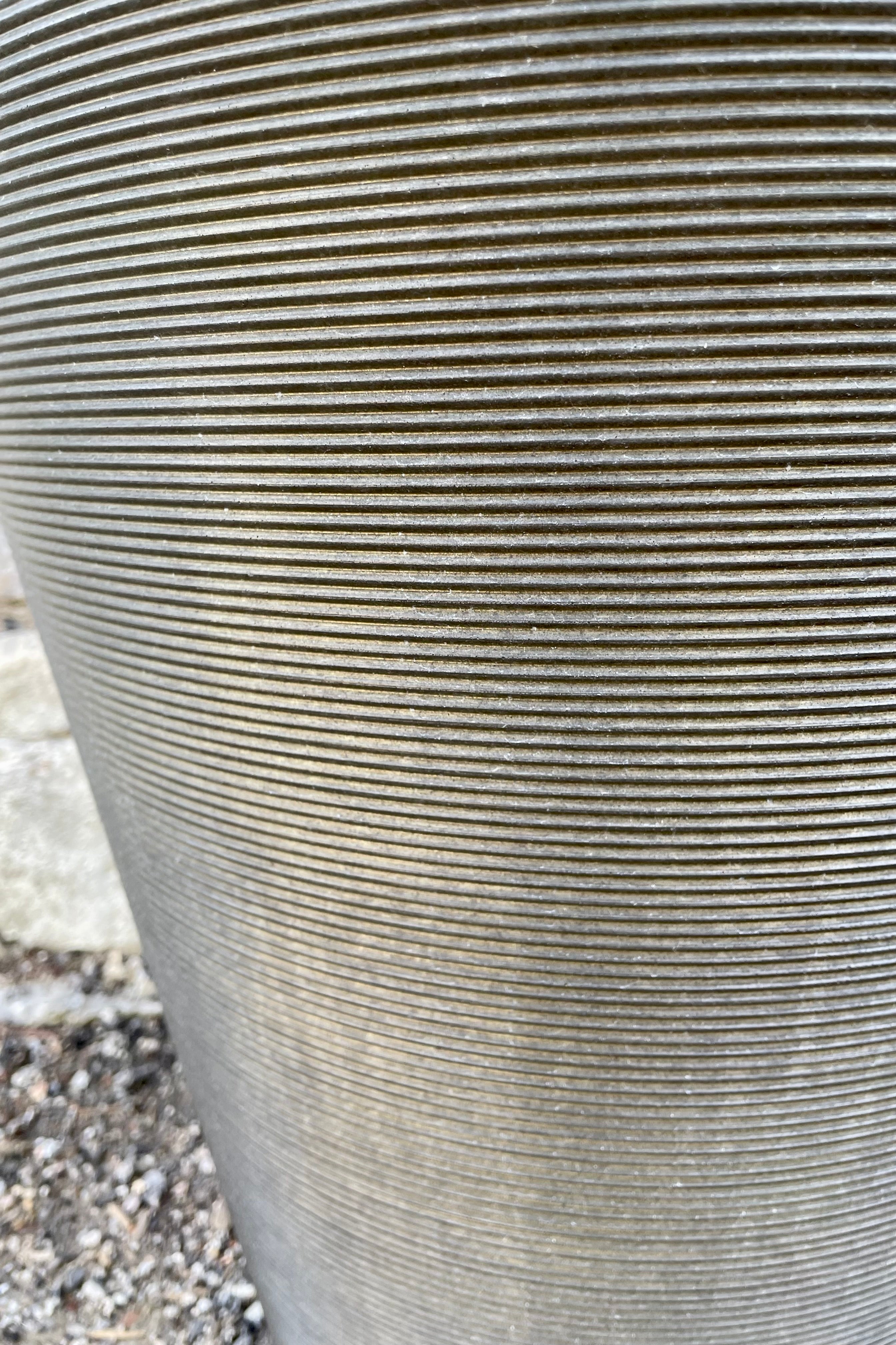 A detail shot of the horizontal ridges of the old bronze madison planter.