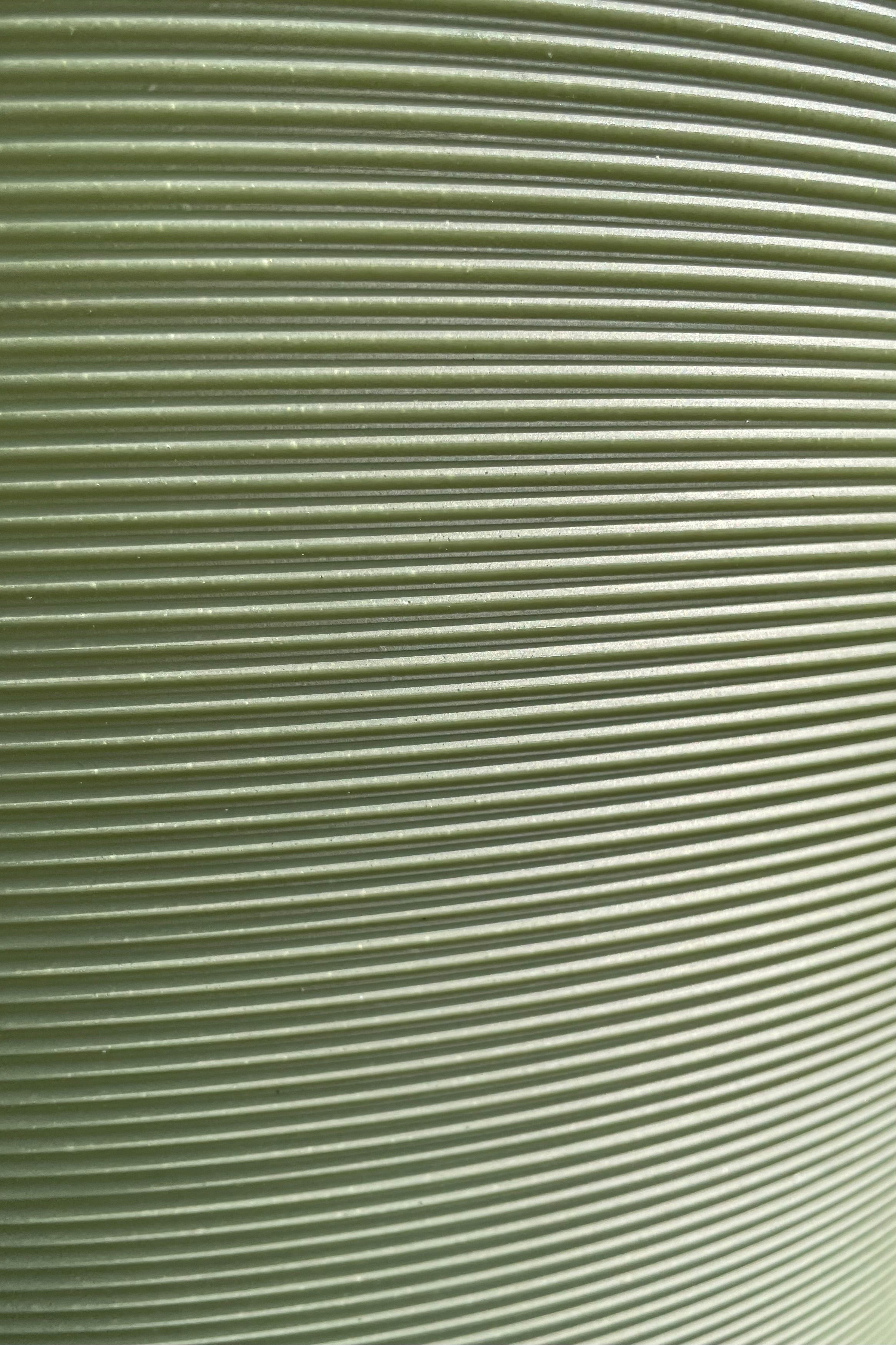 A close up picture of the horizontal ridges of the olive madison planter.