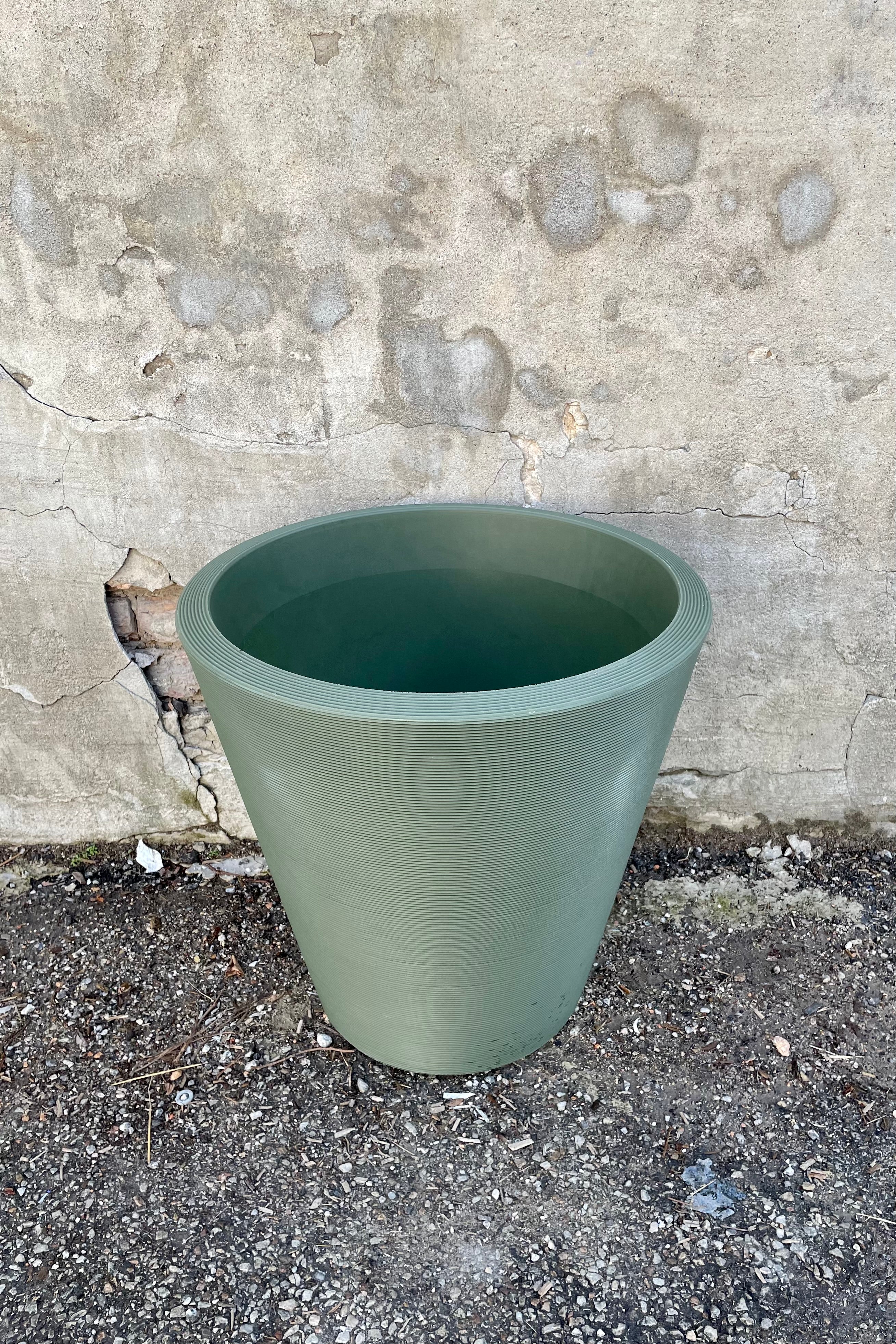 The olive 20" Madison planter against a concrete wall shown from above and the side.