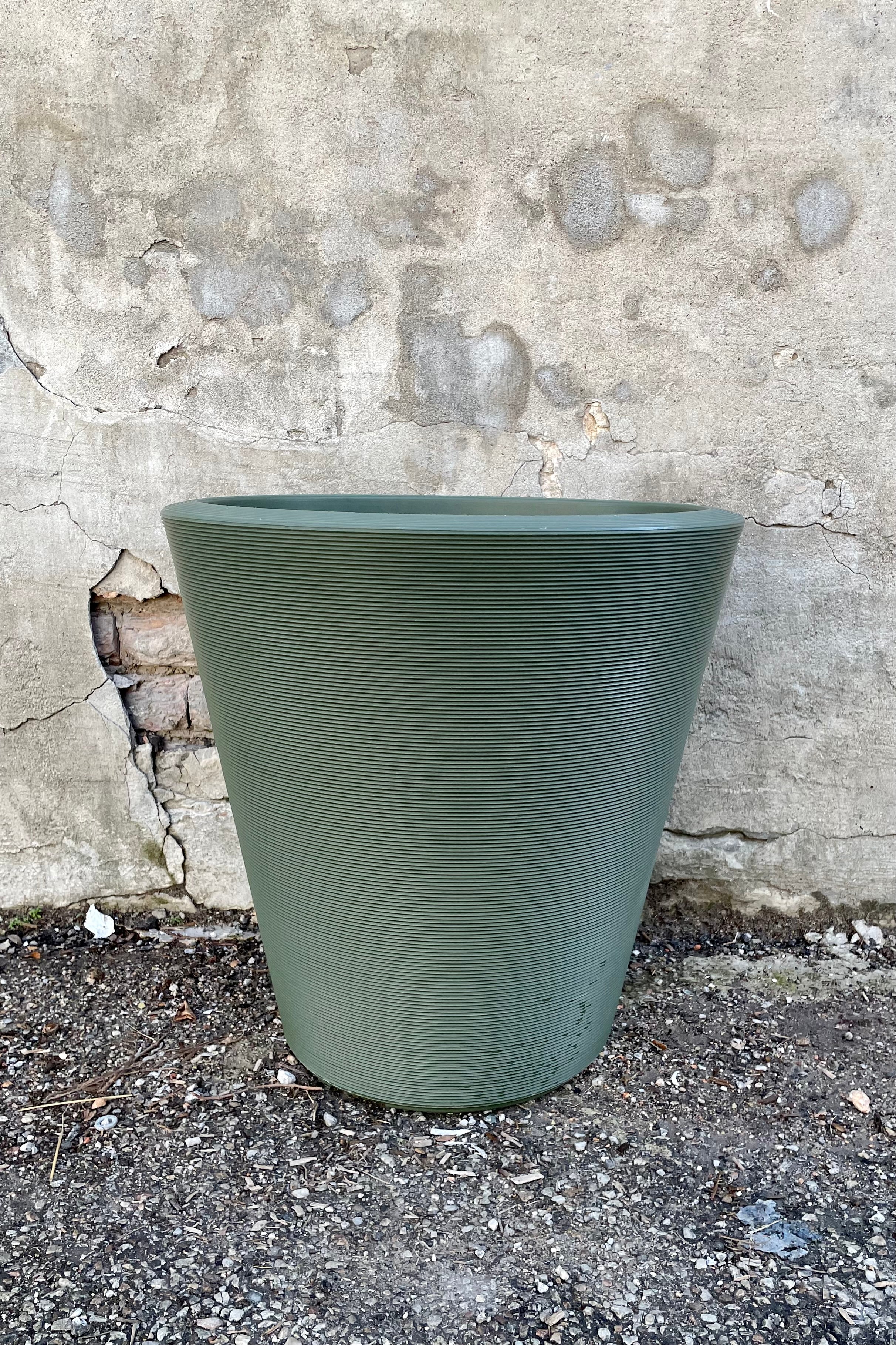 The olive 20" Madison planter against a concrete wall.