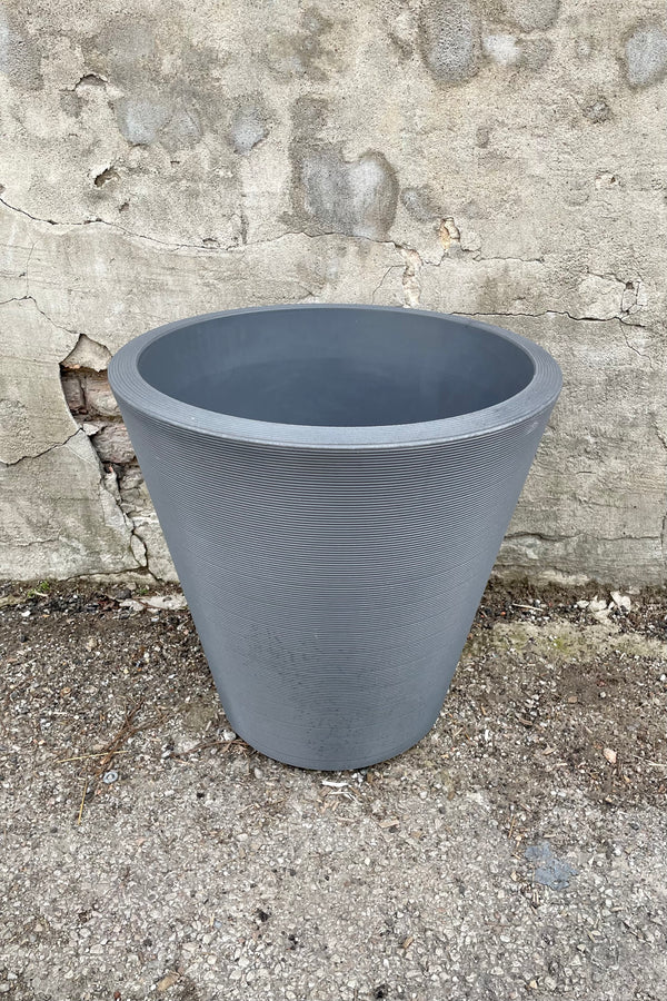 The 20" slate madison planter against a concrete wall. 