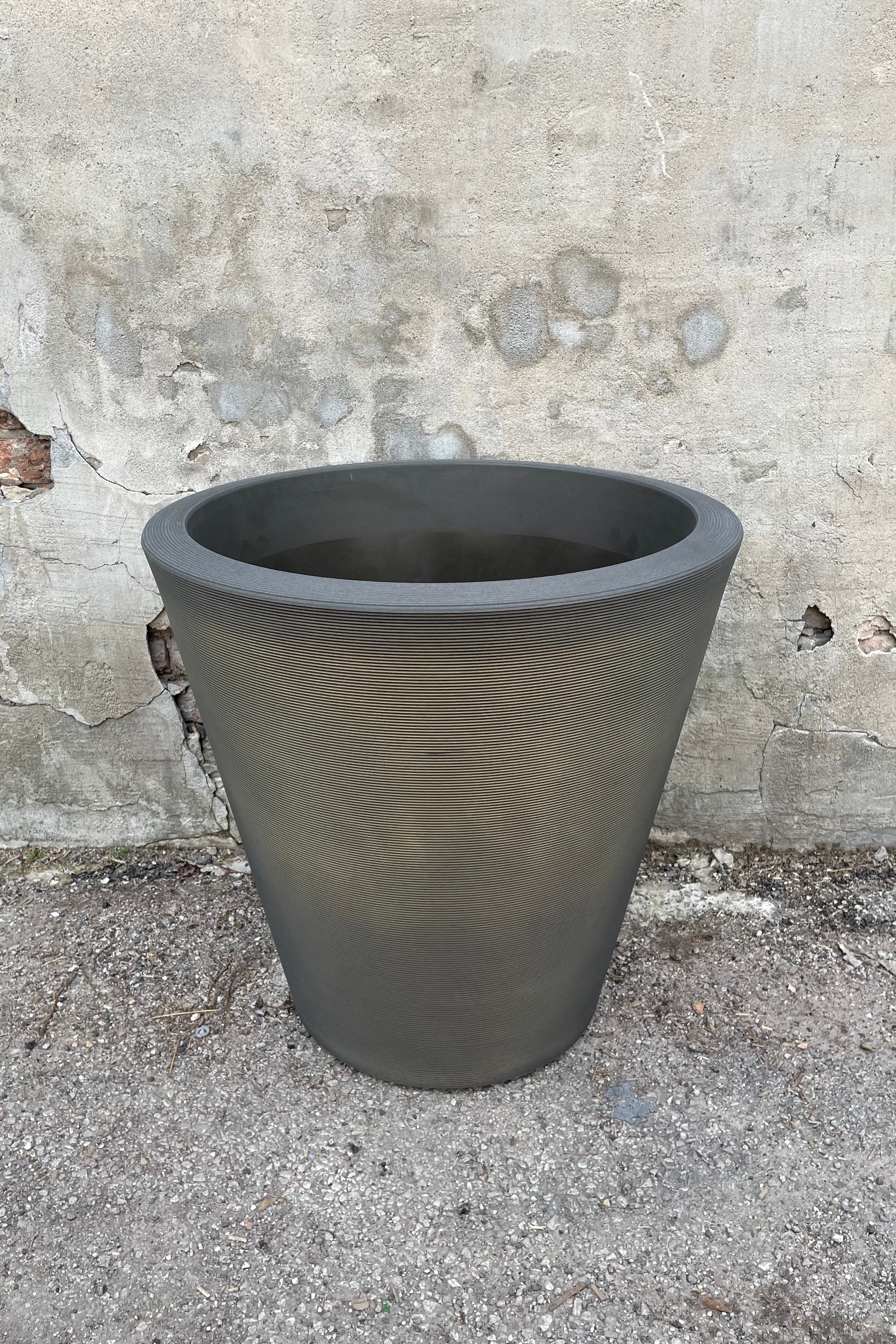 The old bronze Madison pot in 26" against a cement wall.