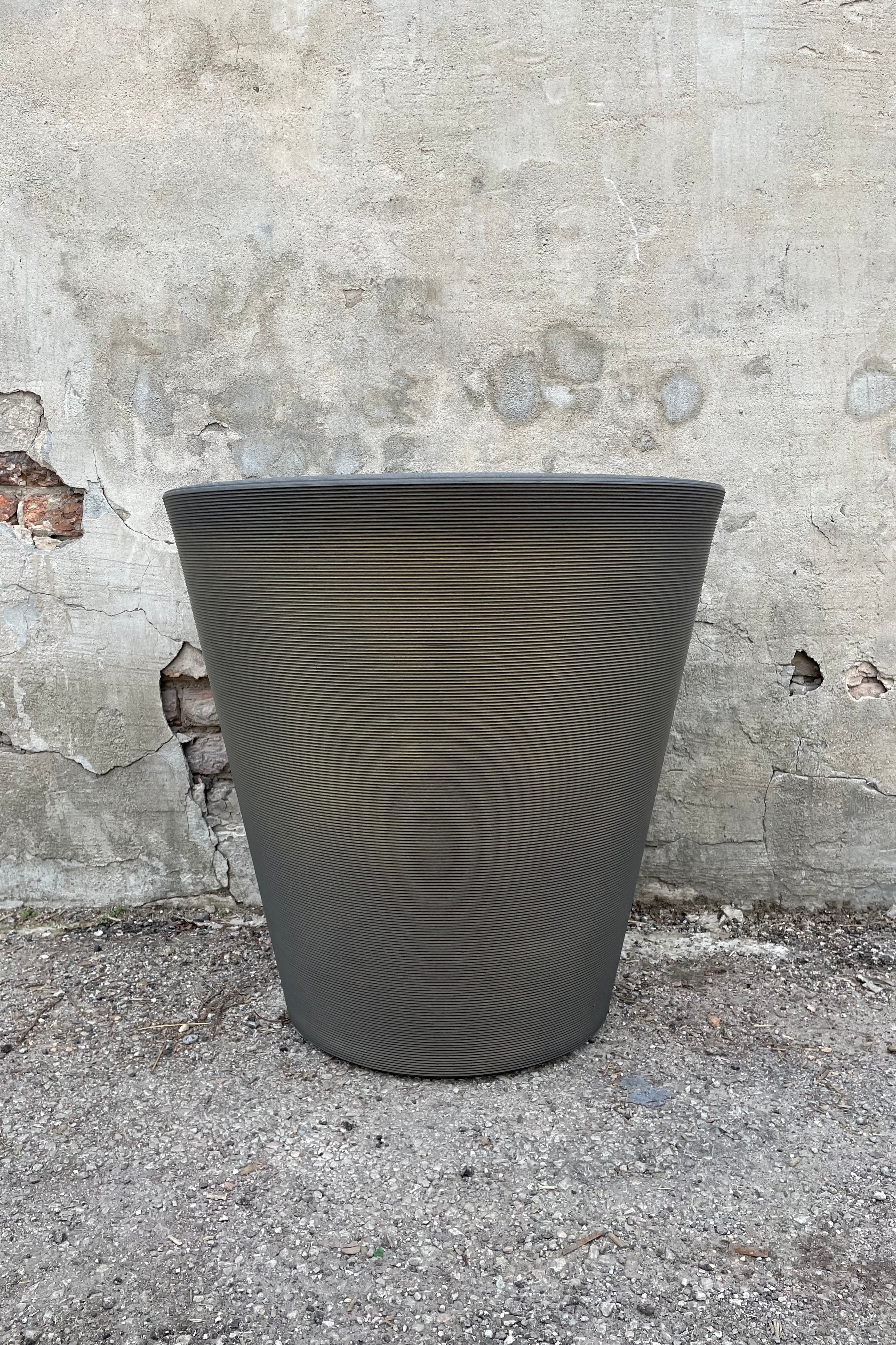 The old bronze Madison pot in 26" against a cement wall.