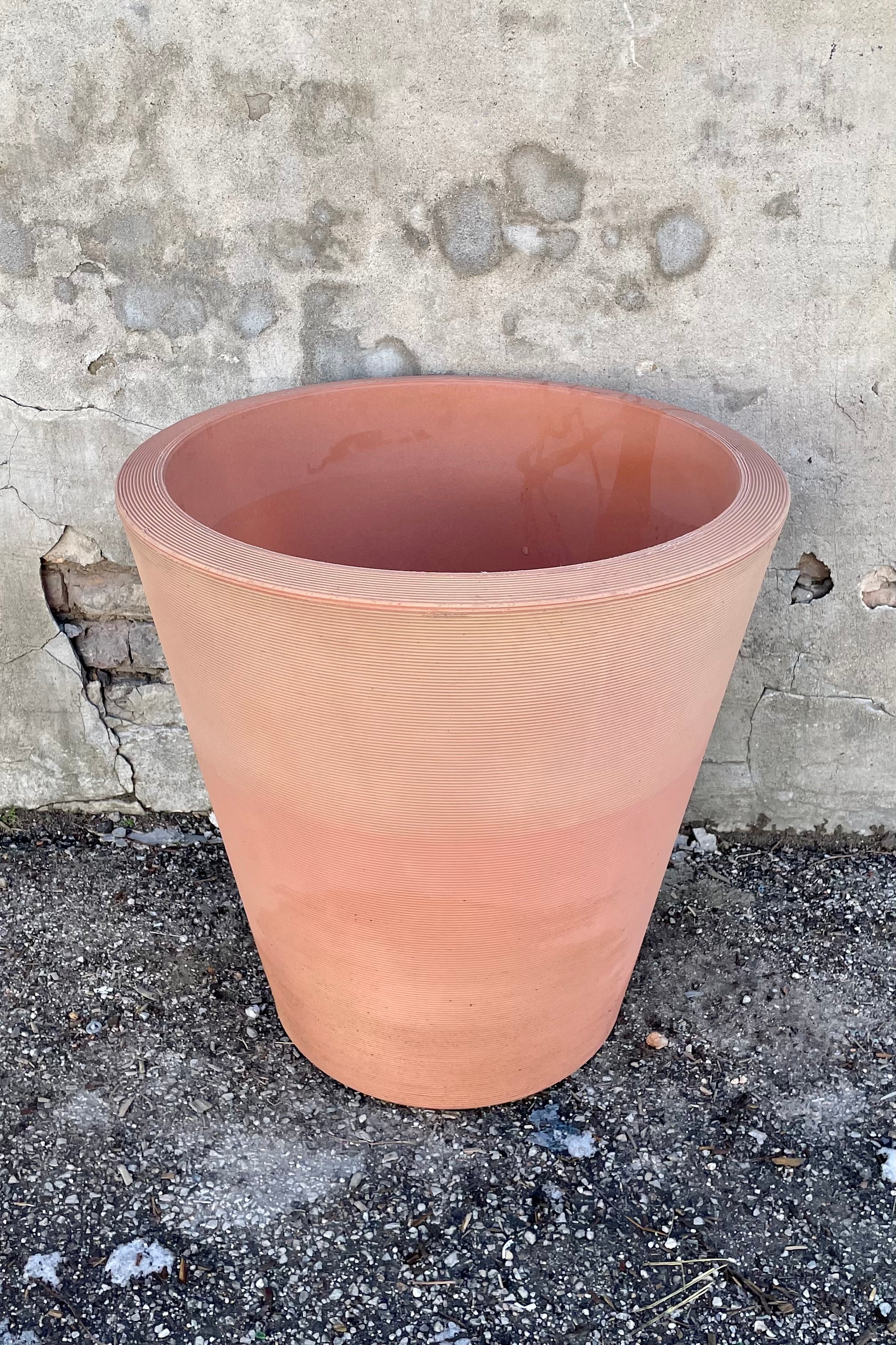 26" weathered terracotta 26" Madison planter in front of a concrete wall.