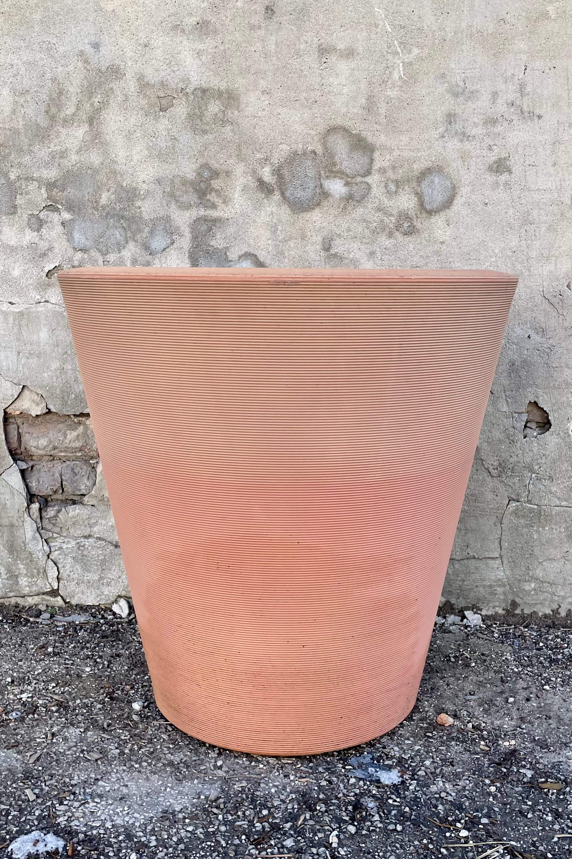 26" weathered terracotta 26" Madison planter in front of a concrete wall.