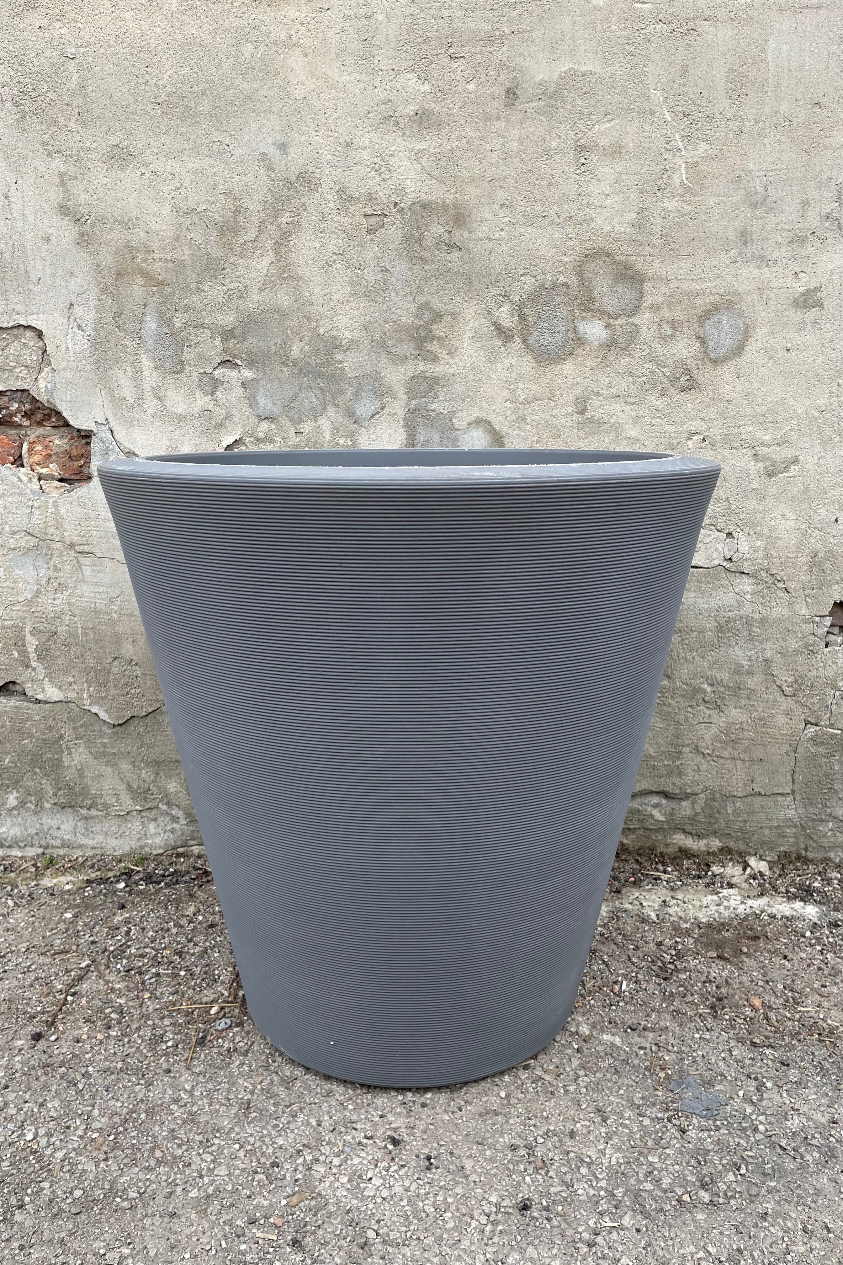 The 26" Slate Madison Slate planter against a cement wall.