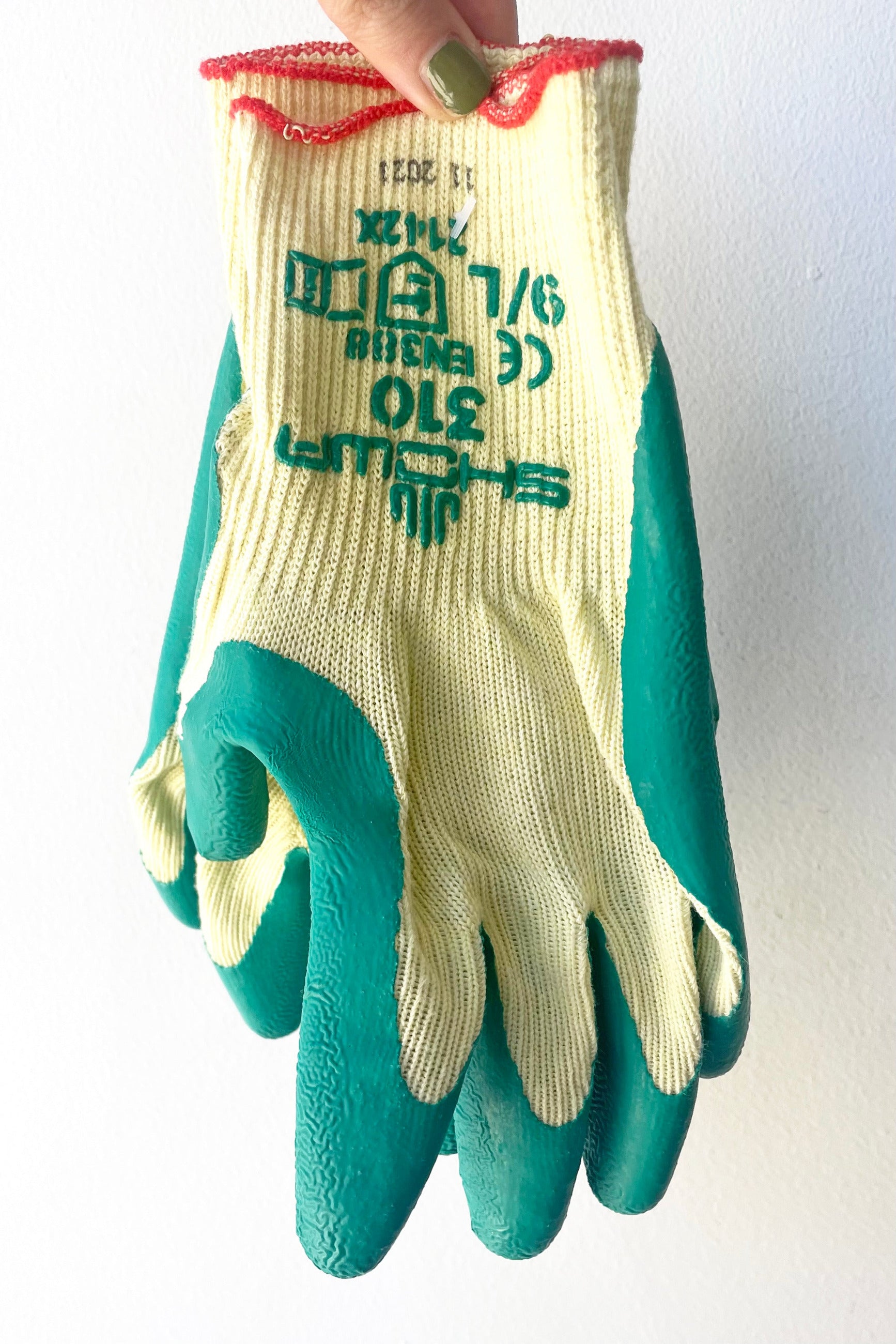 A hand holds pair of Atlas Super Grip Gloves Large against white backdrop ©Sprout Home