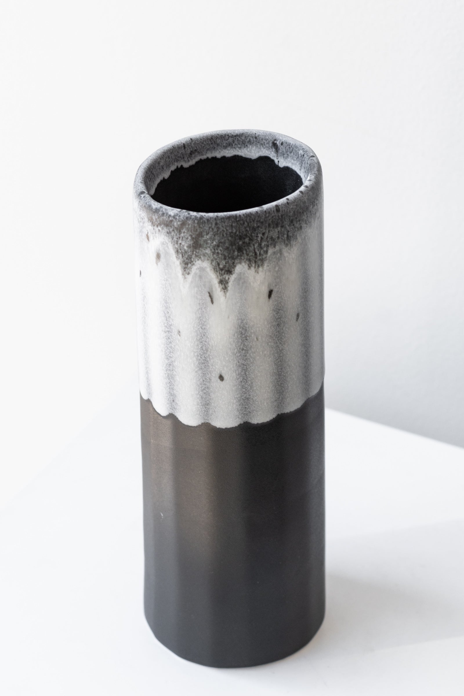 Bloom Vase in Night Snow by The Bright Angle sits on a white surface in a white room