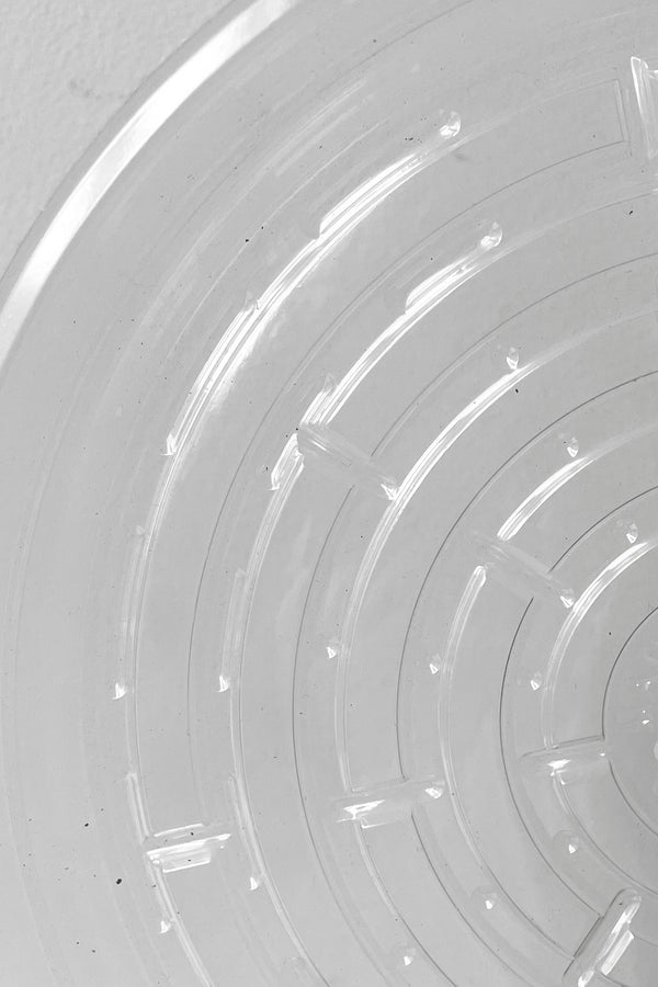 A detailed view of interior ridges on Plastic Saucer 10" against white backdrop
