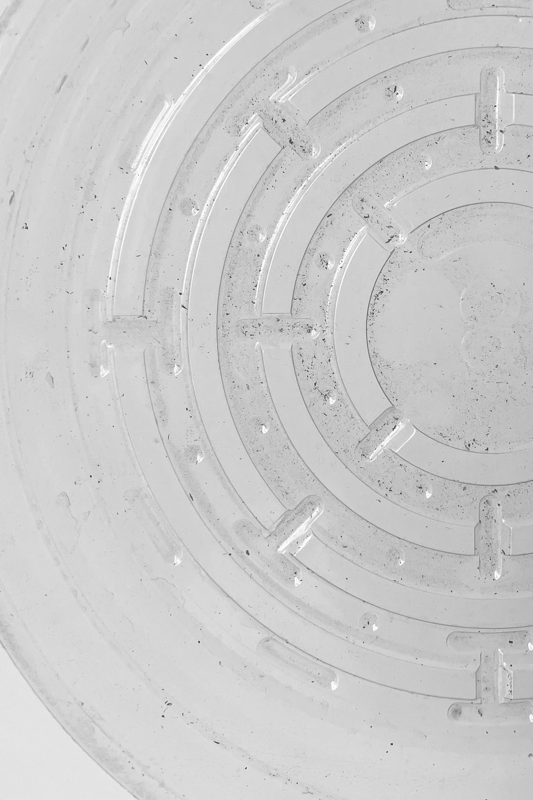 A detailed view of interior ridges of Plastic saucer 8" against white backdrop