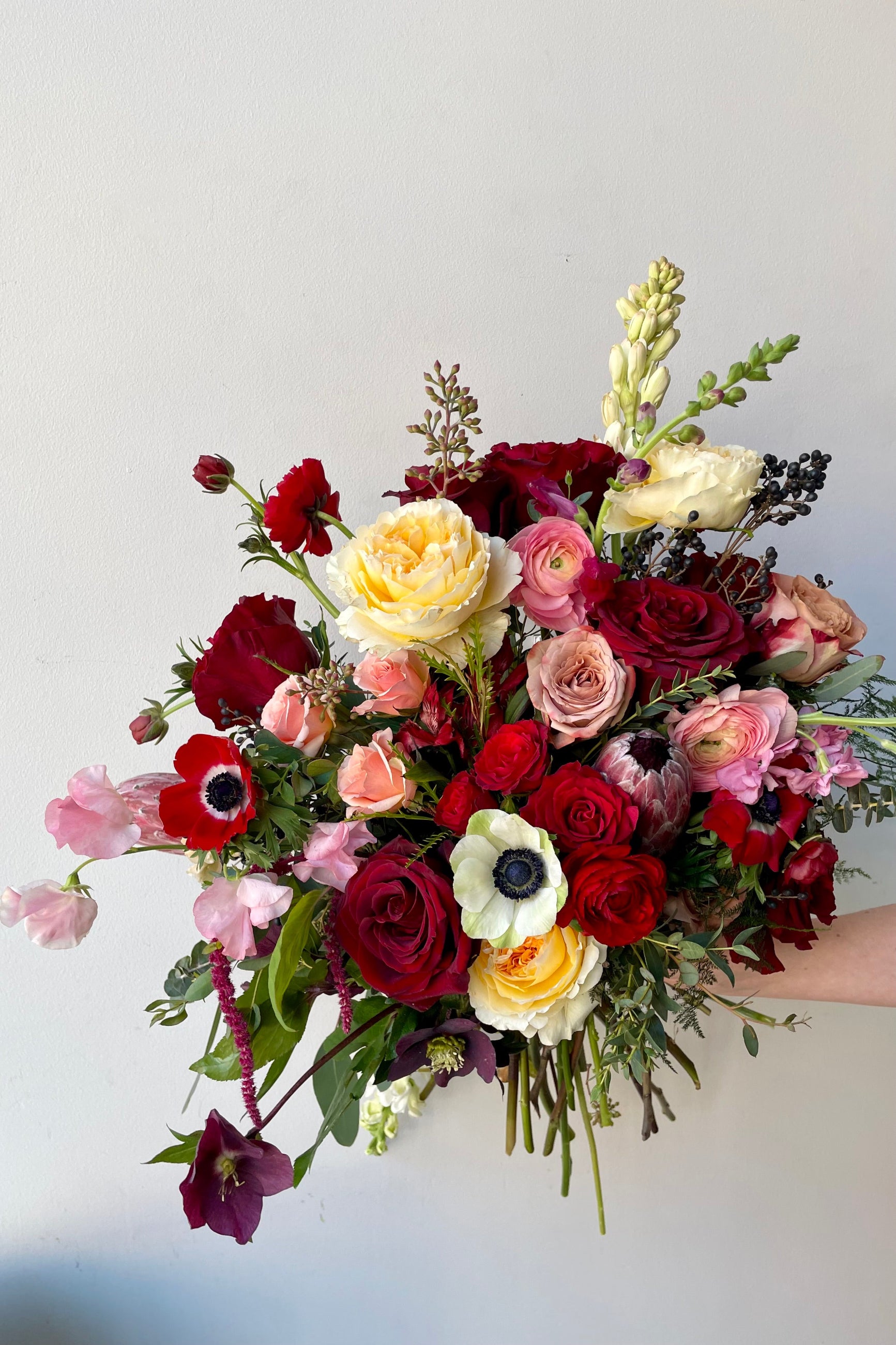 A hand holds an example of fresh Floral Arrangement Modern Love from Sprout Home Floral in Chicago for Valentine's Day ©Sprout Home #size_$200