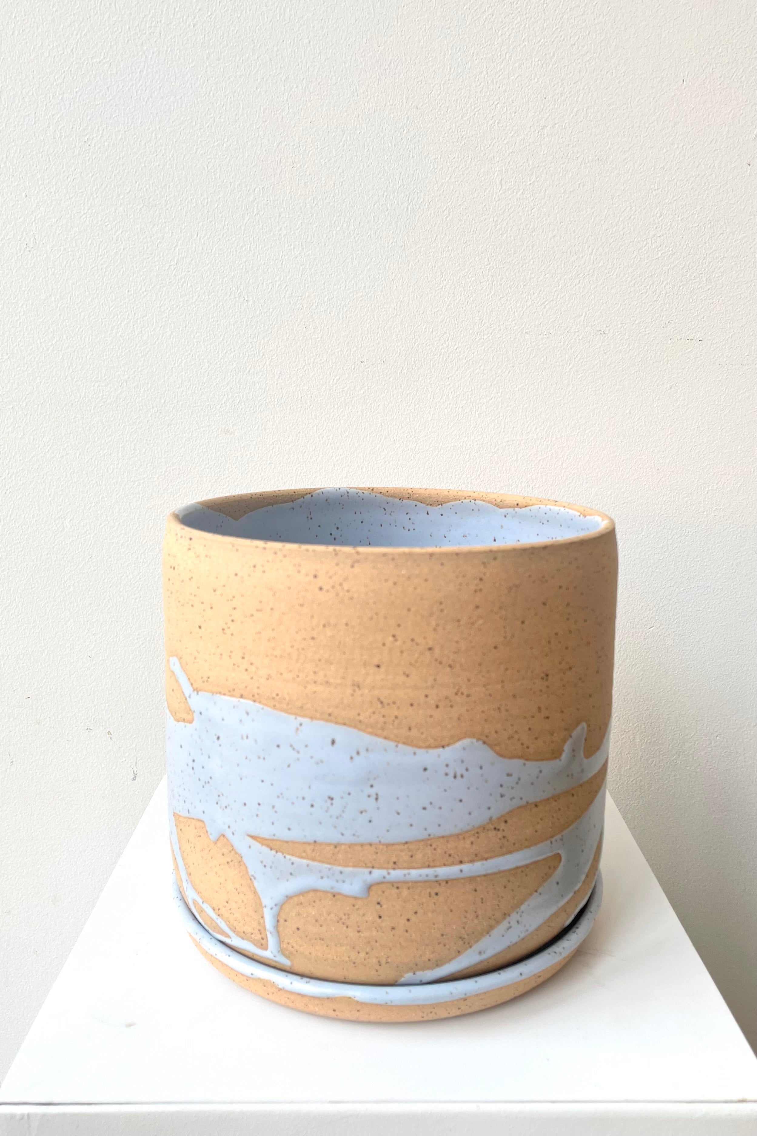 A slight over-the-lip view of the 6.5" cylinder pot and saucer in blue against a white backdrop