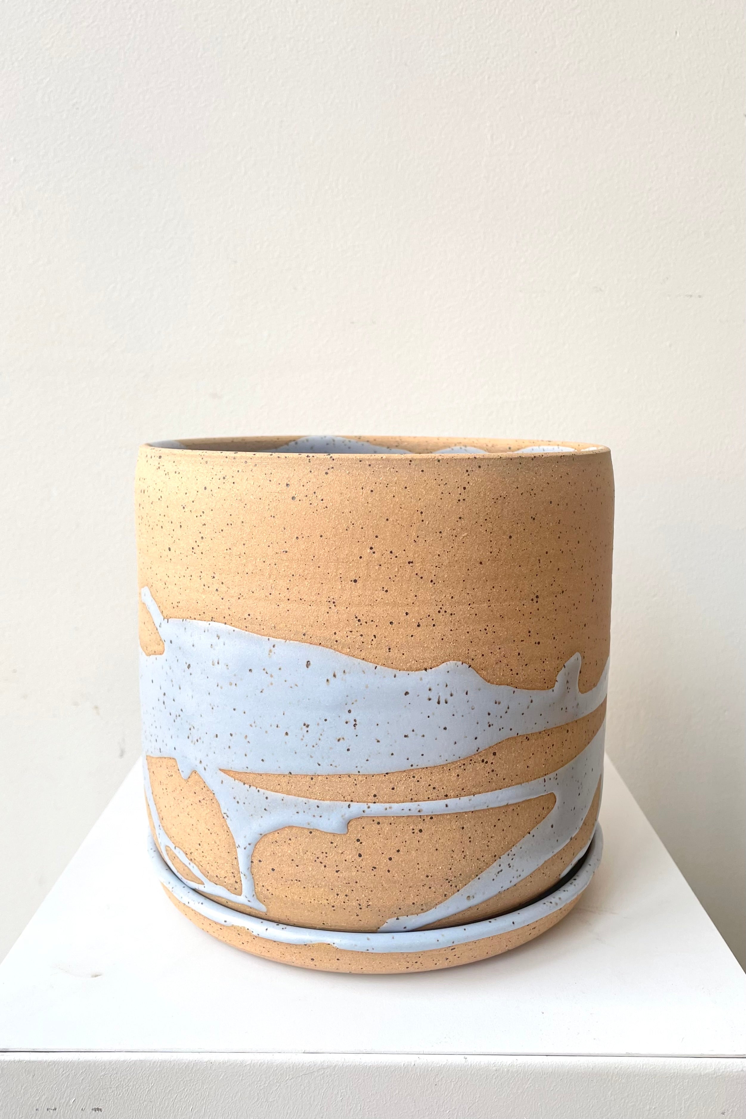 A frontal view of the 6.5" cylinder pot and saucer in blue against a white backdrop