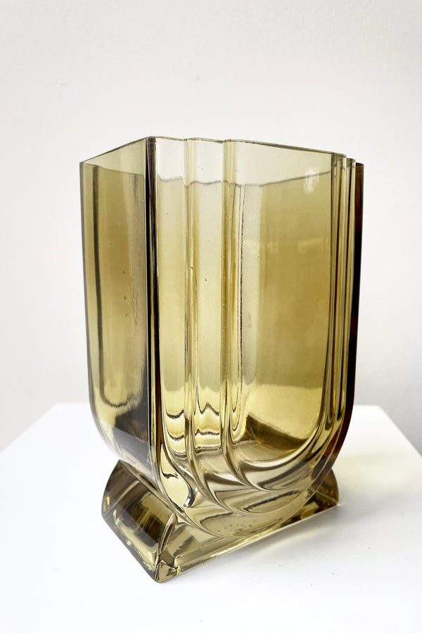 A slight side view of the Deco Glass Vase in amber against a white backdrop