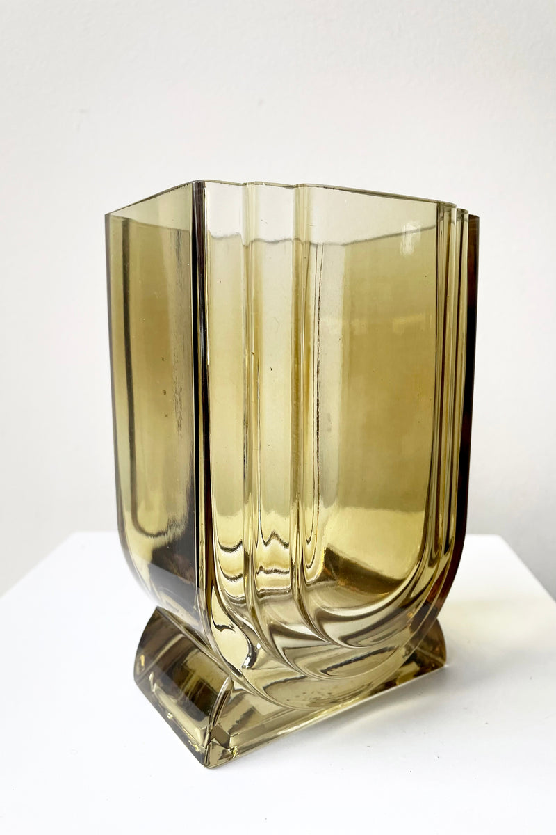 A slight side view of the Deco Glass Vase in amber against a white backdrop