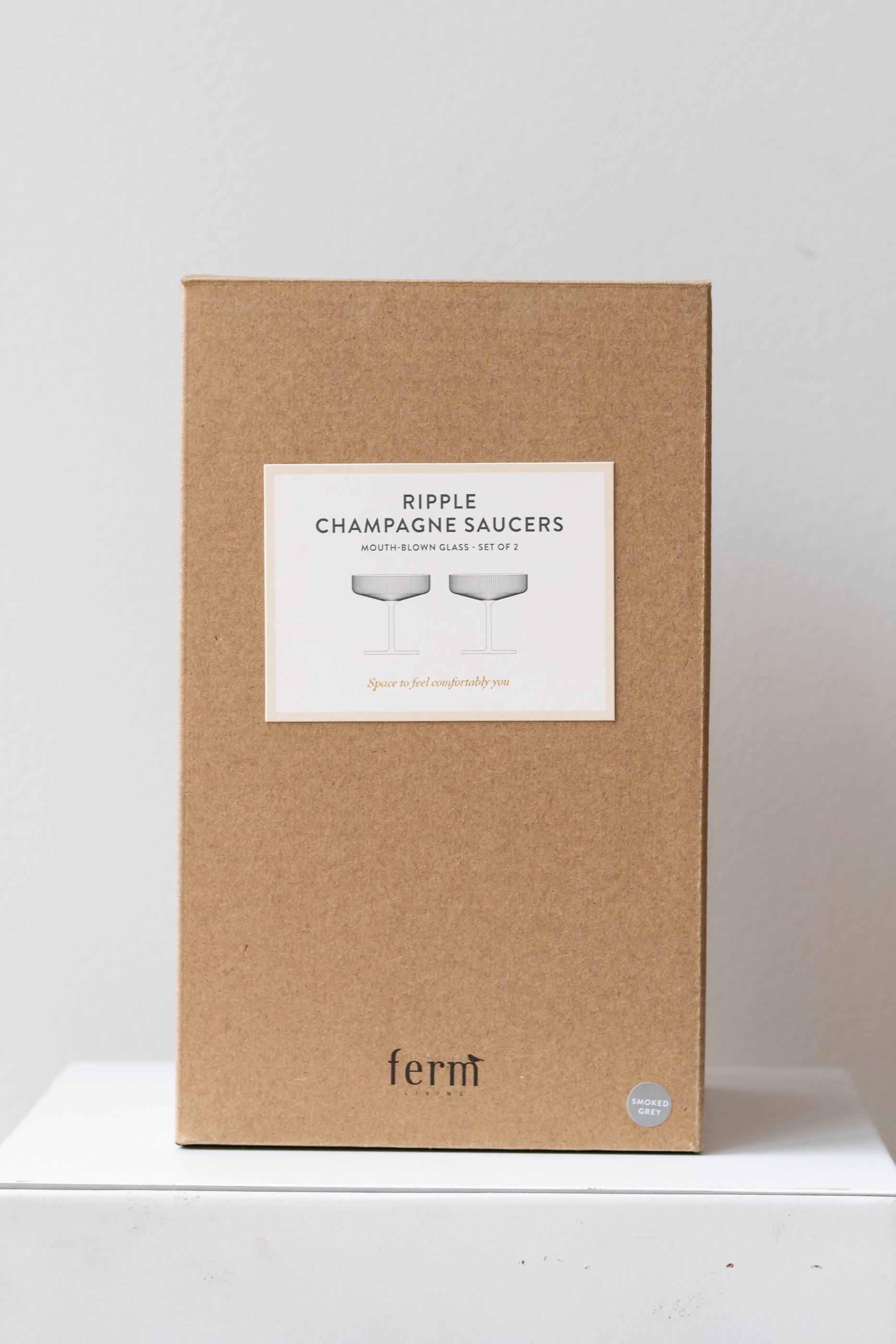 Box for Ferm Living Ripple Champagne Saucers Set of 2 glass smoke on a white surface in a white room