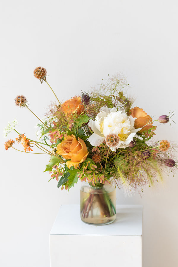 Small Dusk floral arrangement by Sprout Home sits on a white pedestal in front of a white background