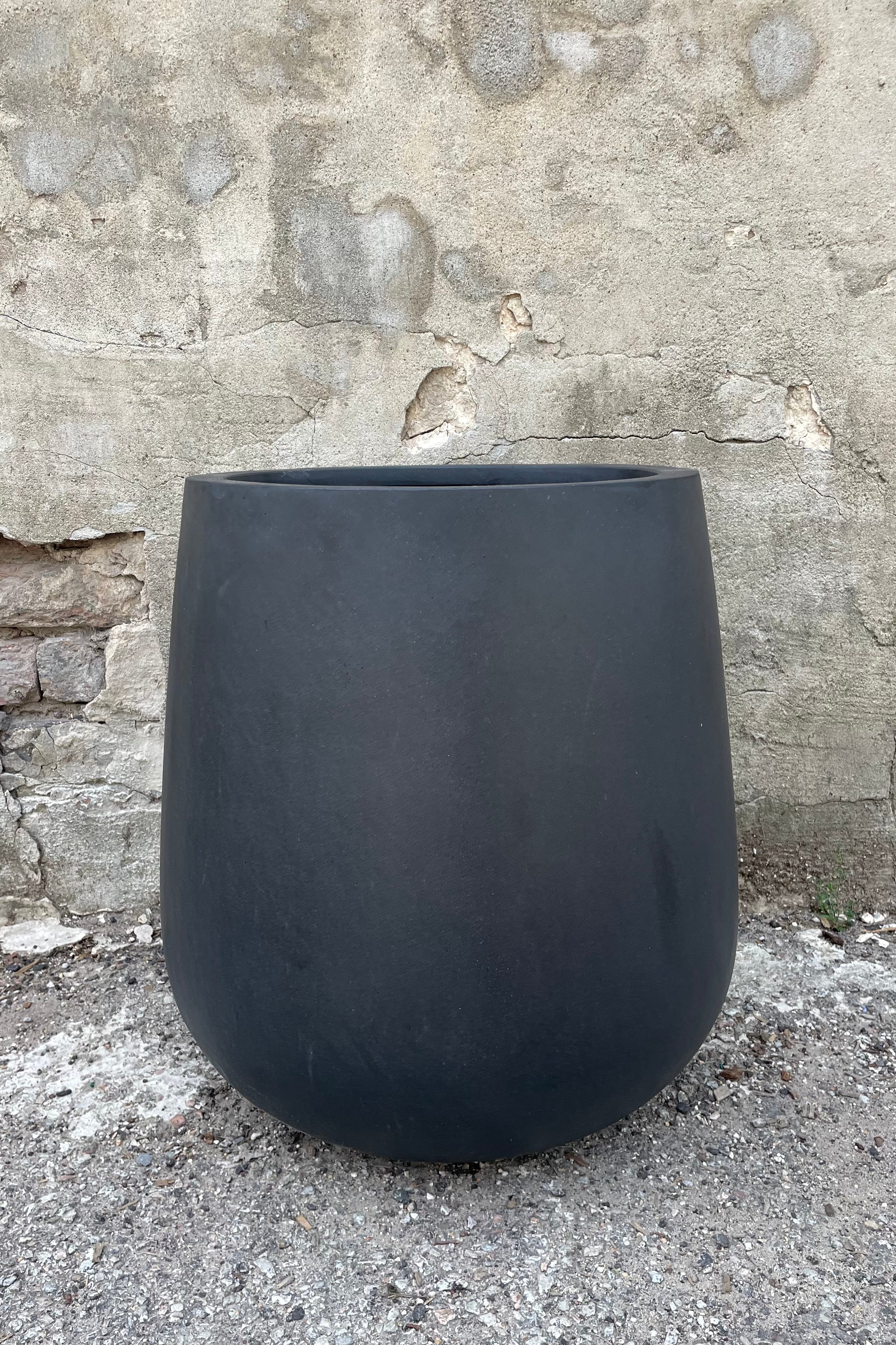 Pax Pot Fiberstone Black Medium straight on against a grey wall