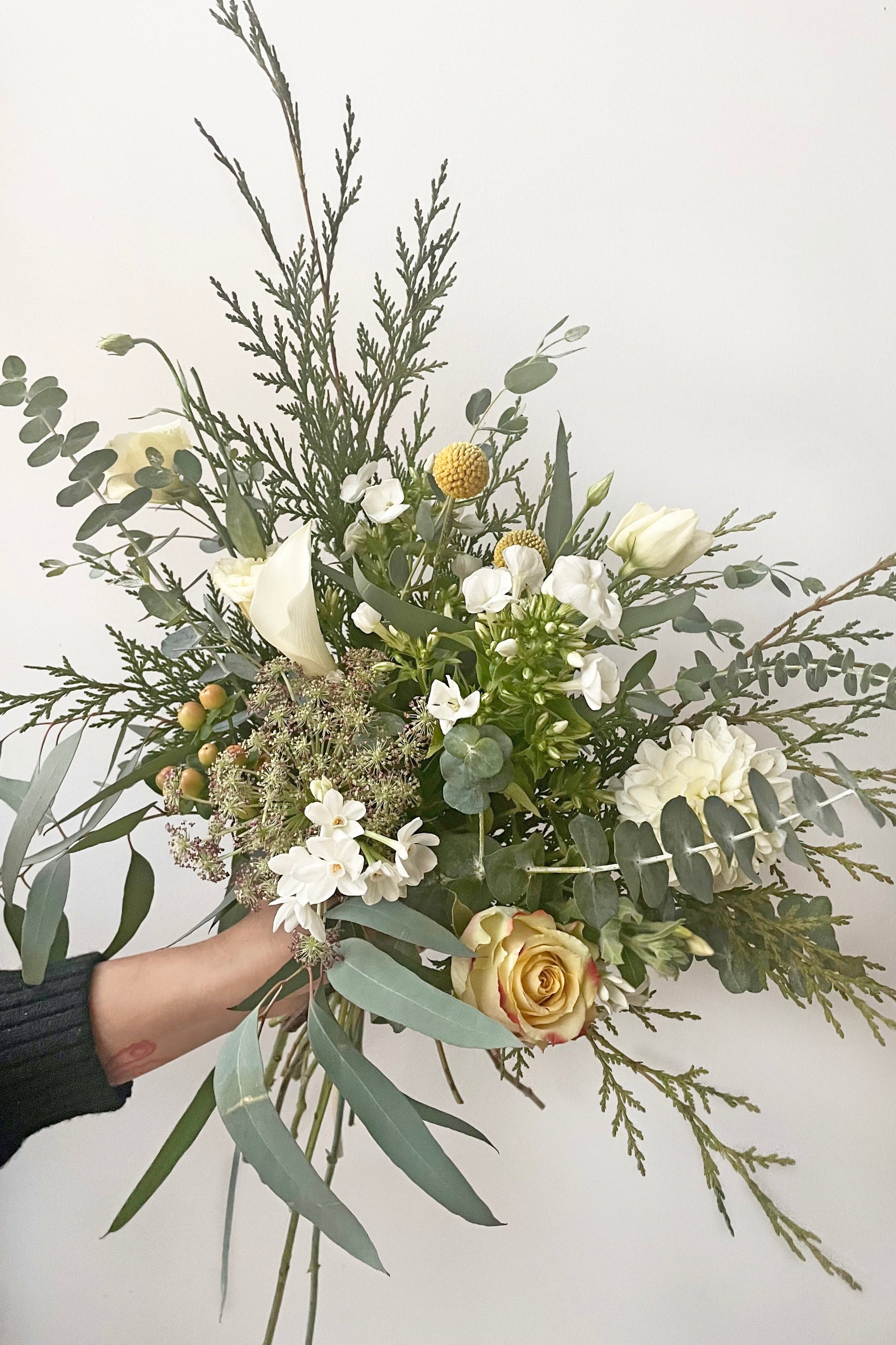 A hand holds an example of fresh Floral Arrangement Eggnog by Sprout Home Floral in Chicago ©Sprout Home #size_$75