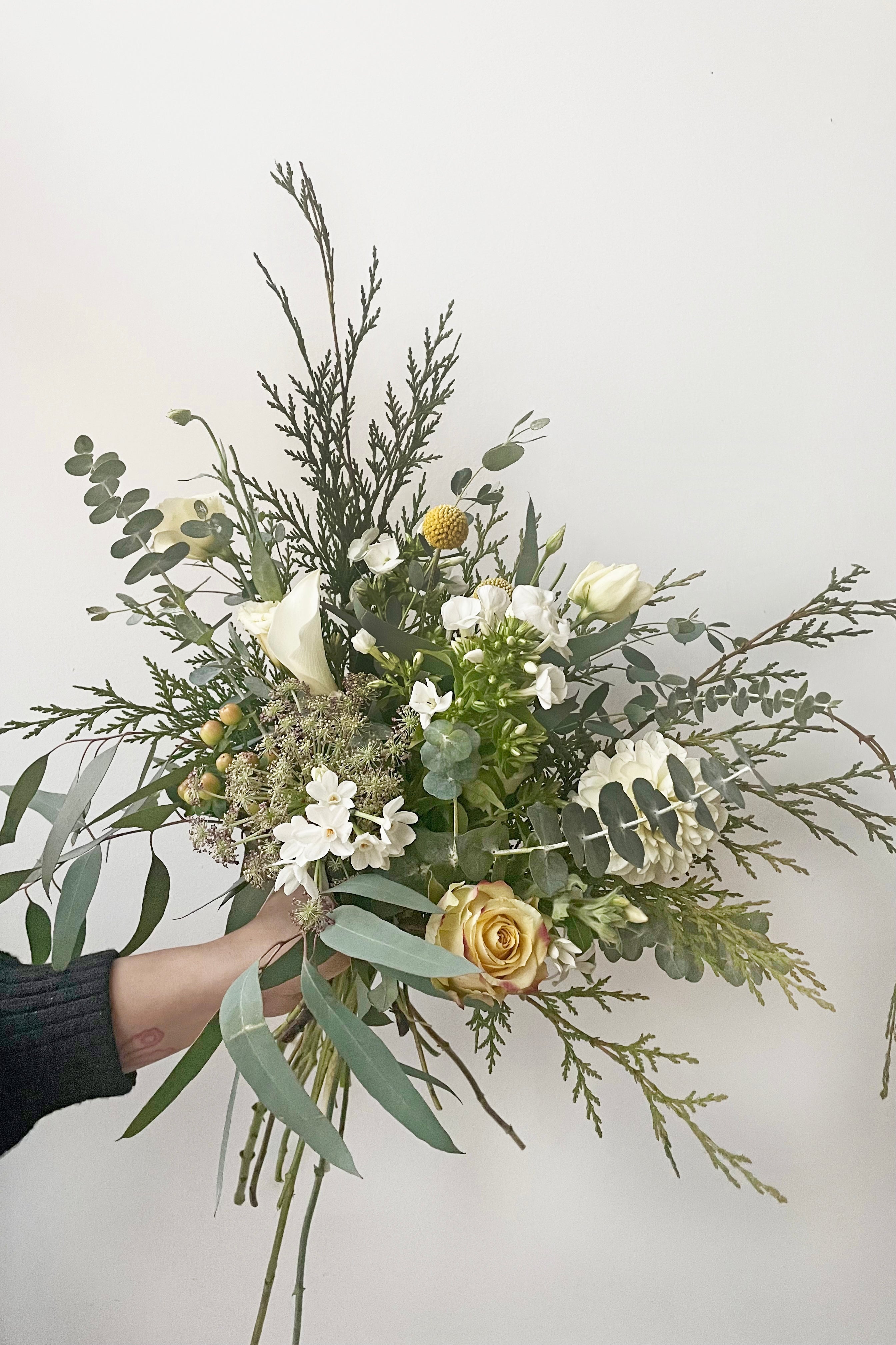 A hand holds an example of fresh Floral Arrangement Champagne Toast for $65 by Sprout Home Floral in Chicago #size_$65