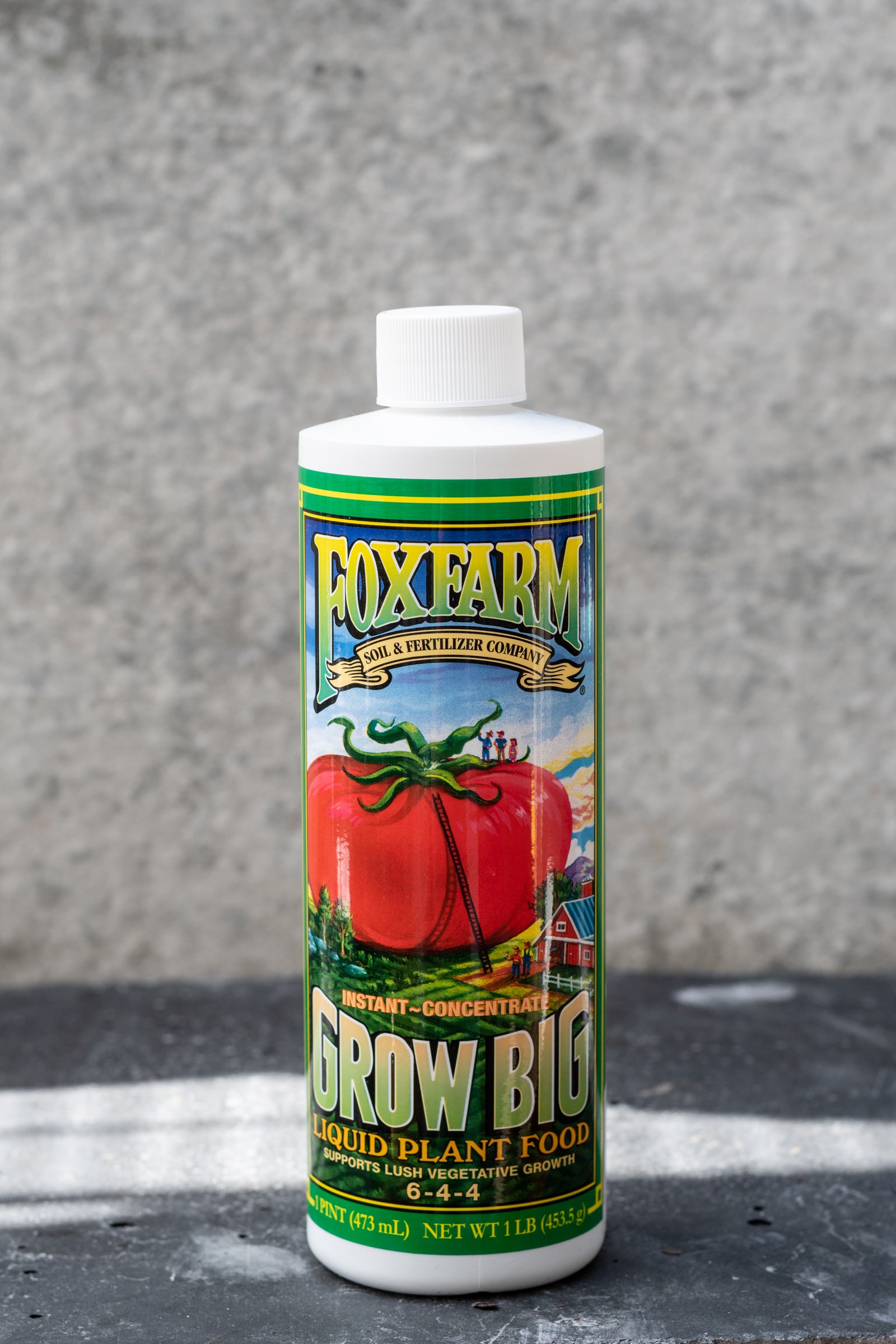 A bottle of FoxFarm grow big liquid fertilizer showing the graphic large tomato farm image.