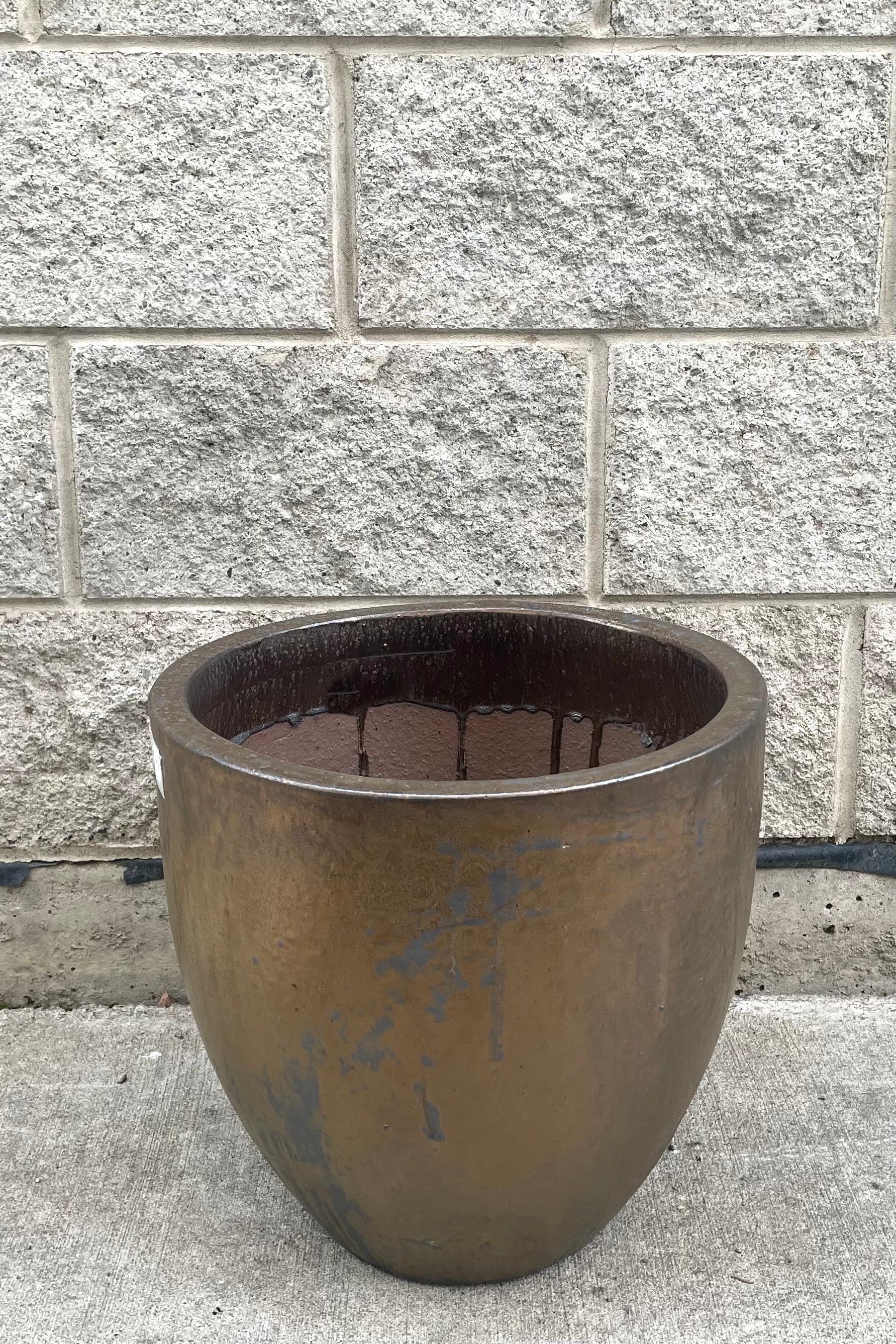 A full frontal view of Egg Ceramic Planter Heavy Metal Large against concrete backdrop