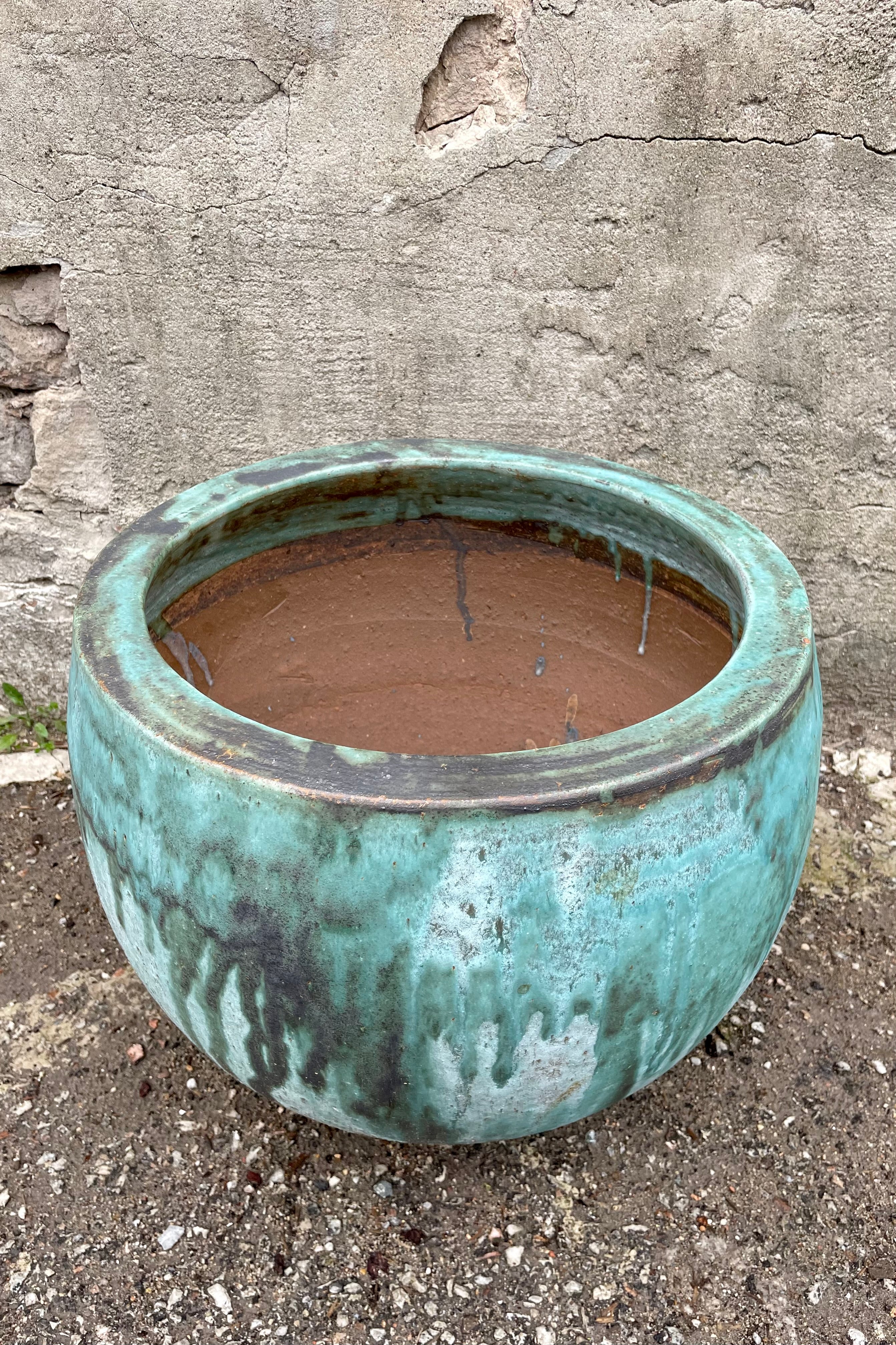Detail of the Malachite Cercle Planter Medium against a grey wall