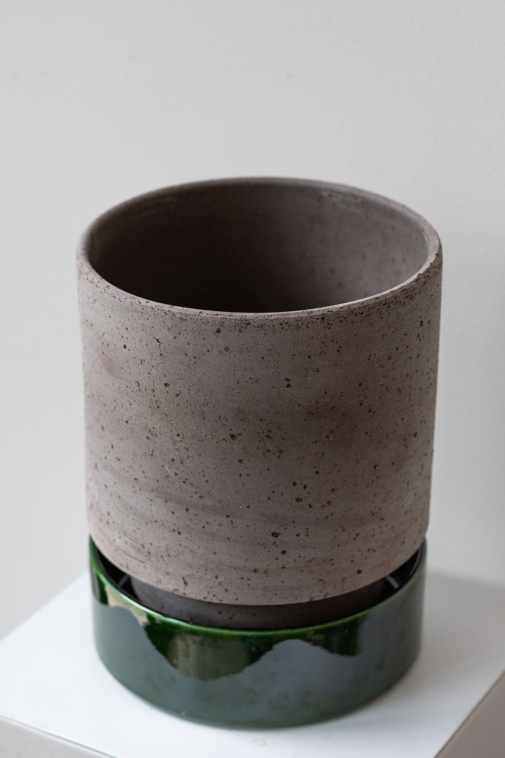 Bergs Potter Hoff Pot & Saucer grey & emerald on a white surface in a white room ©Sprout Home