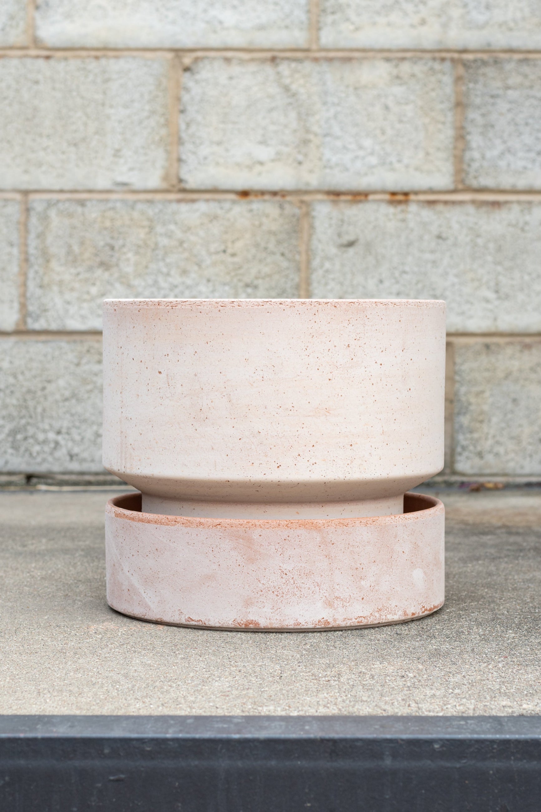 Bergs Potter Hoff Pot & Saucer rosa 11.8” in front of concrete brick wall ©Sprout Home