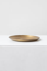 Fog Linen Work medium brass round plate on a white surface in a white room