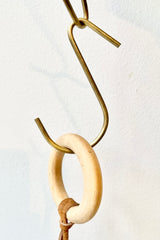 detail of Small brass hook by Fog Linen in front of white background