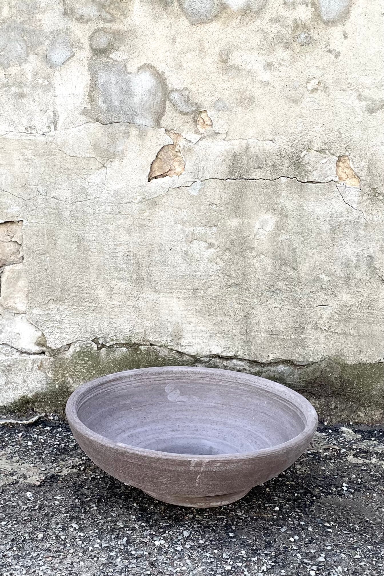 A frontal view of Ada Clay Bowl & Saucer grey 40cm against concrete backdrop ©Sprout Home