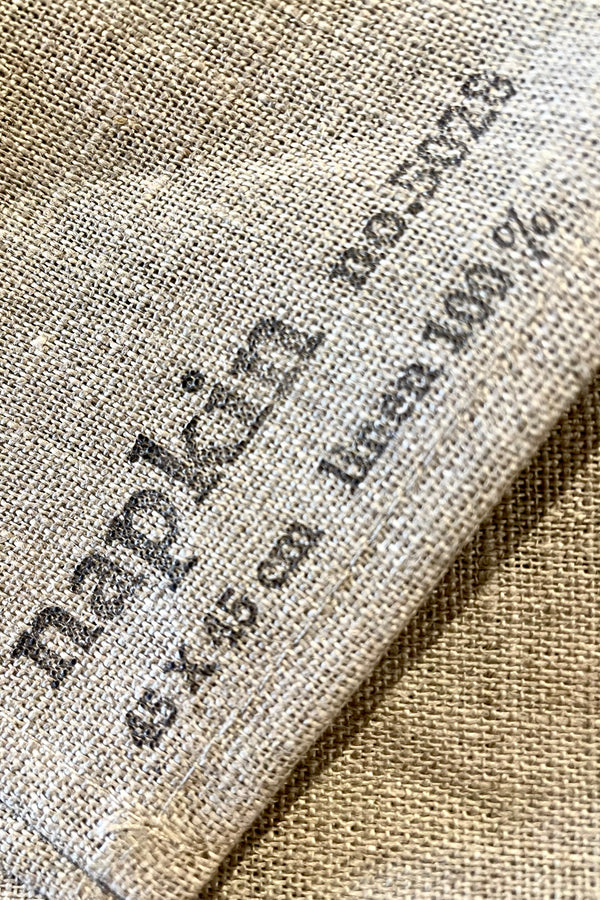 A close-up view of the stamp on the natural linen napkin