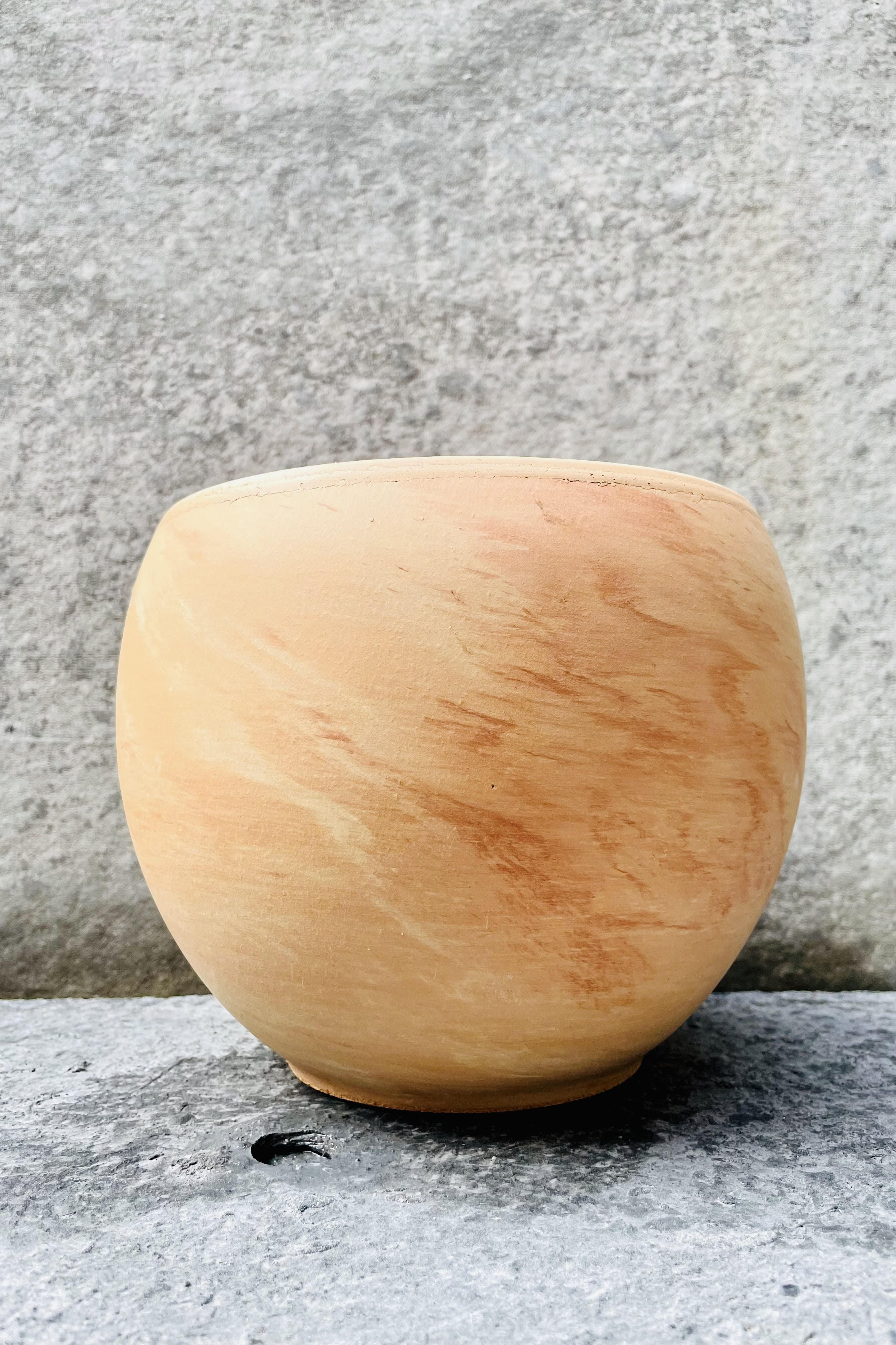 The 7.75 inch, light marble Luna Sphere Pot sits against a grey backdrop.