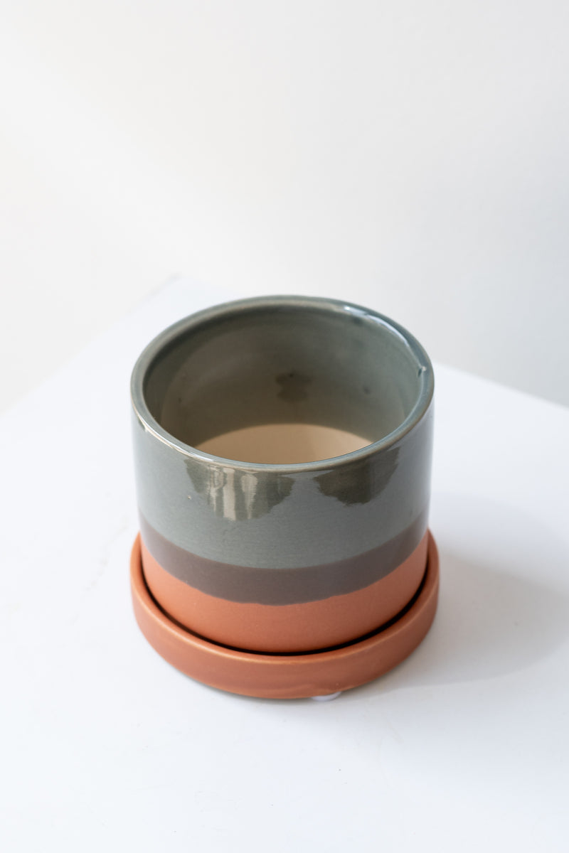 Small Terracotta Minute Pot sits on a white surface in a white room