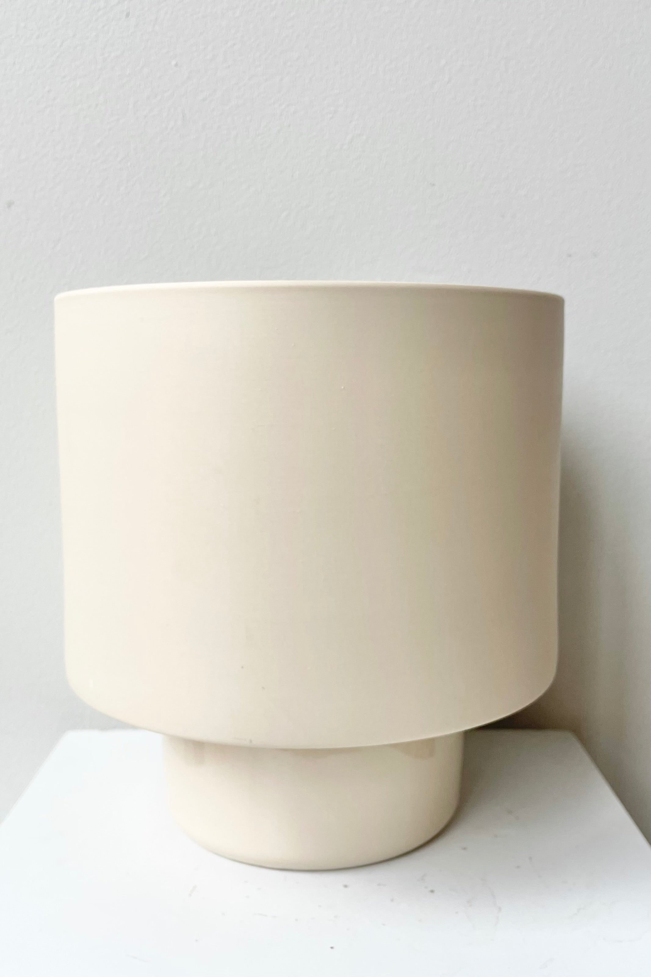 Large clay color Collectors Gro pot against a white wall.