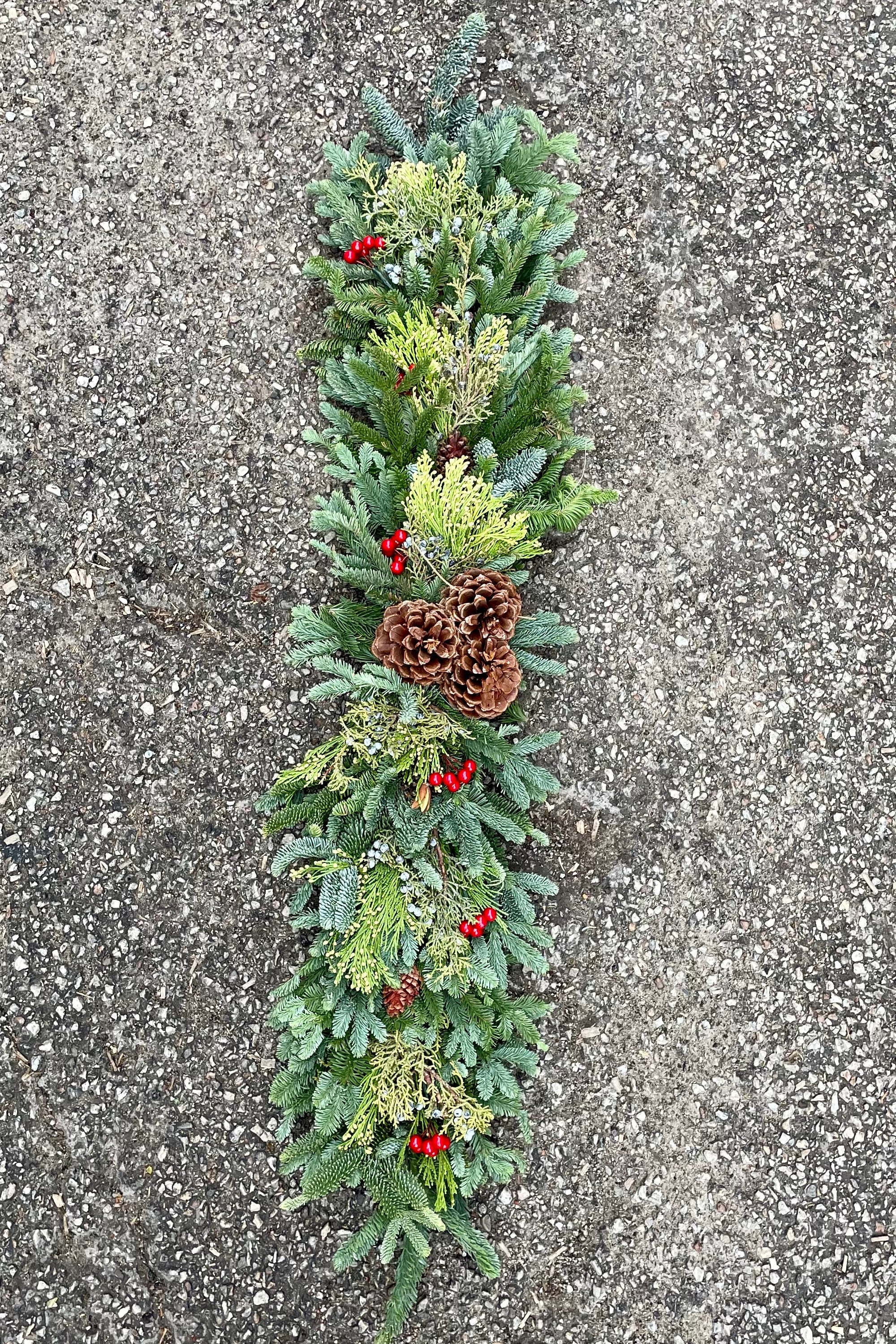 Deluxe swag of evergreen and pine cone to place on a mantle looking from above it.