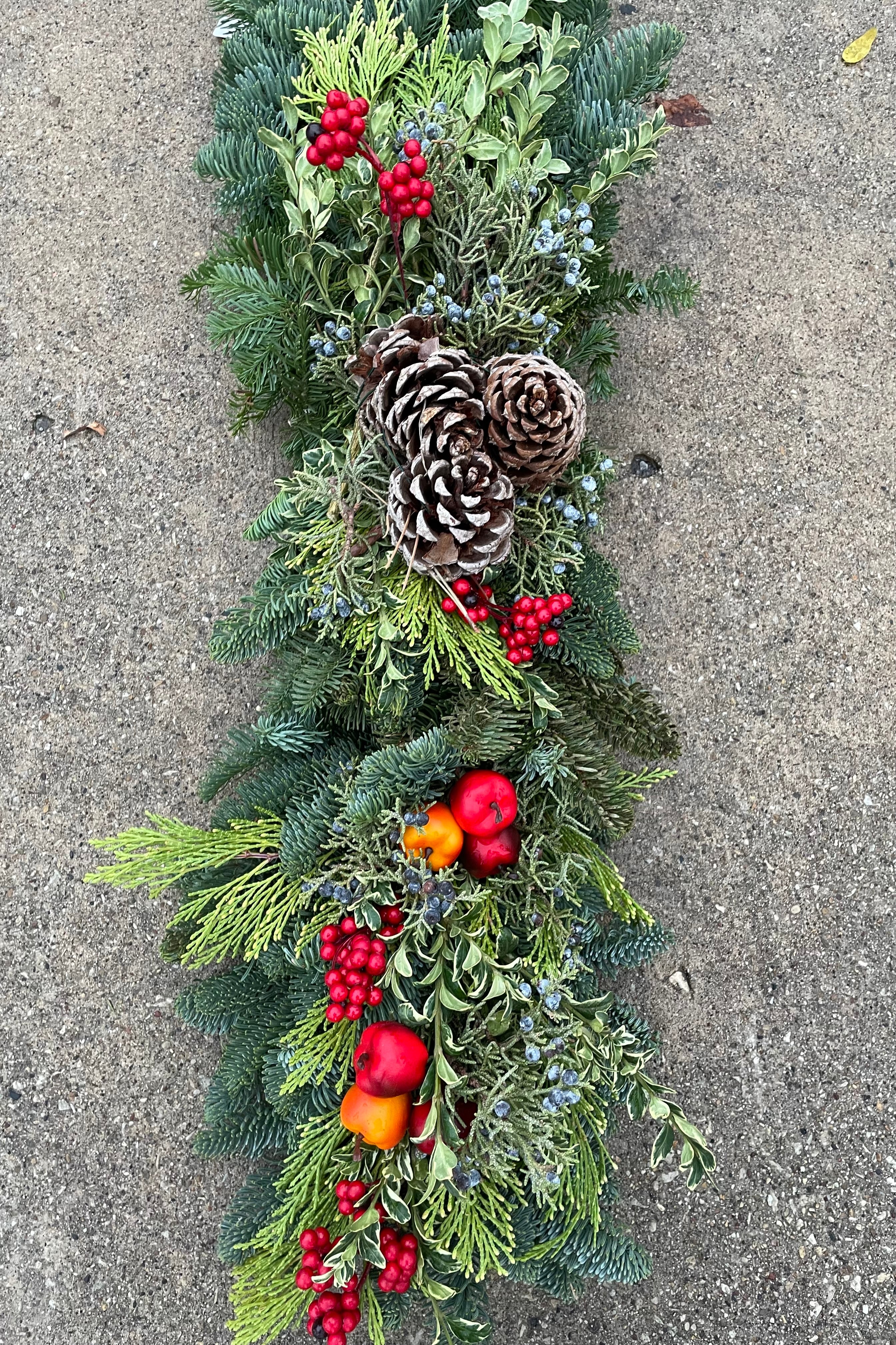 Mantle swag made of mixed evergreen and faux fruit.