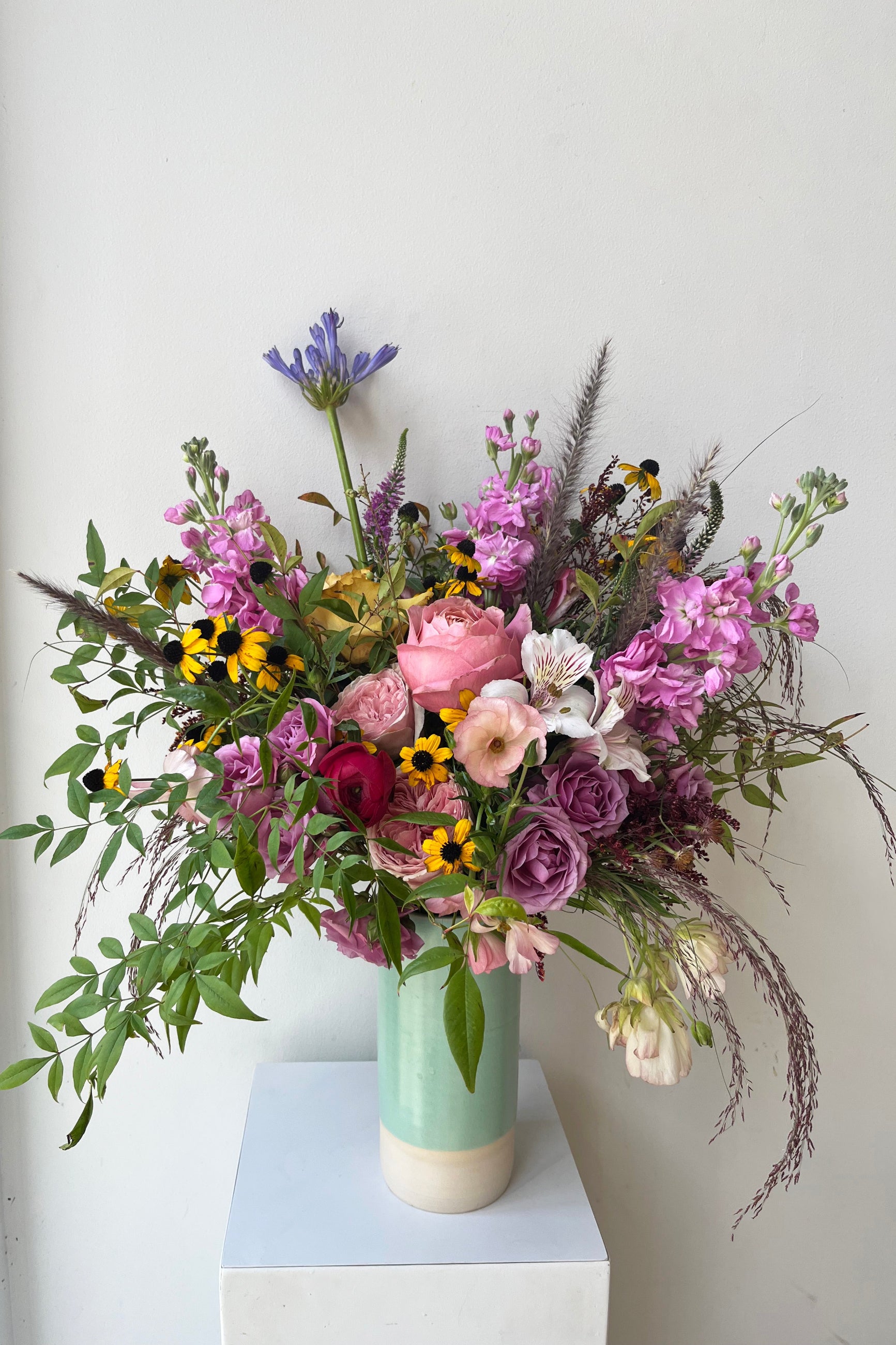 Custo foral arrangement by Sprout Home featuring purple stock, roses and rudbeckia ©Sprout Home #size_$160