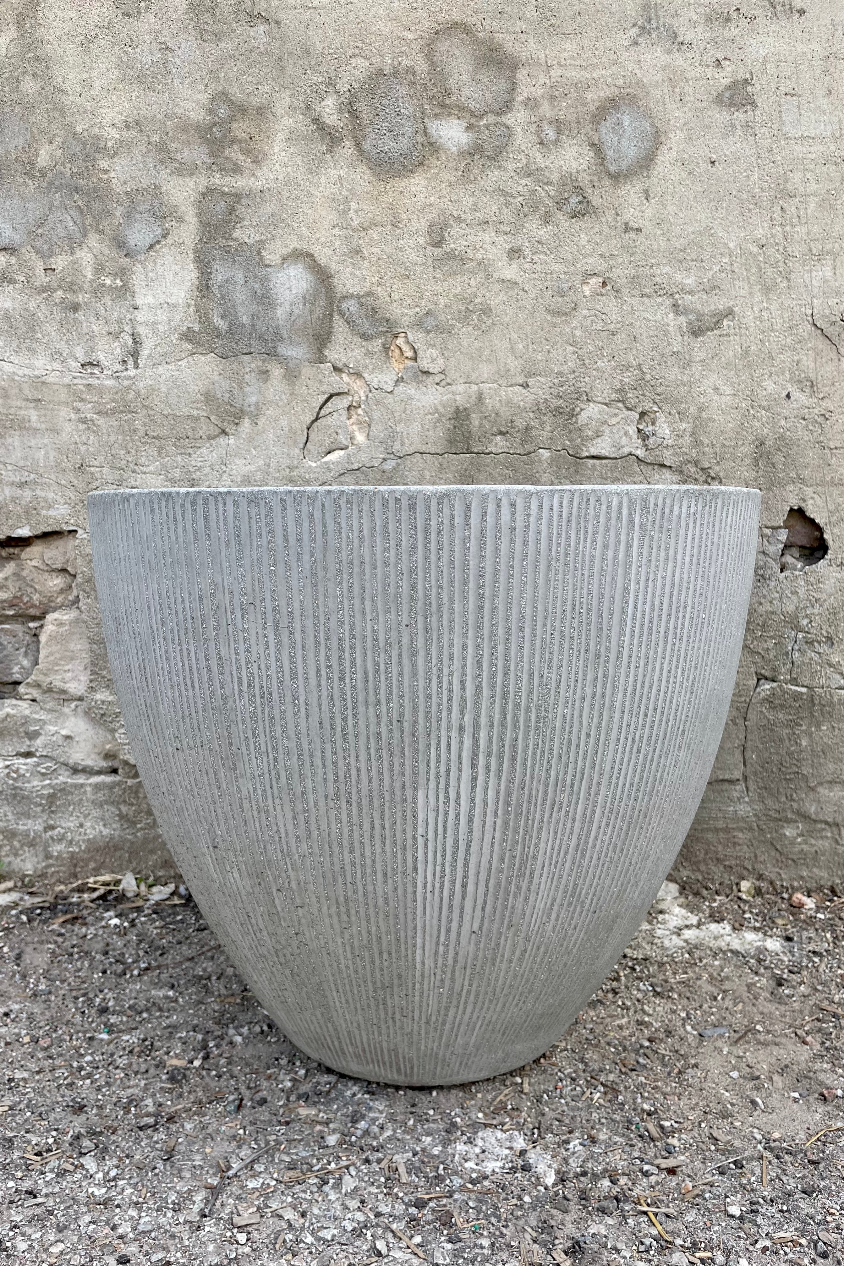 Jesslyn Pot vertical ridged light grey small against a grey wall
