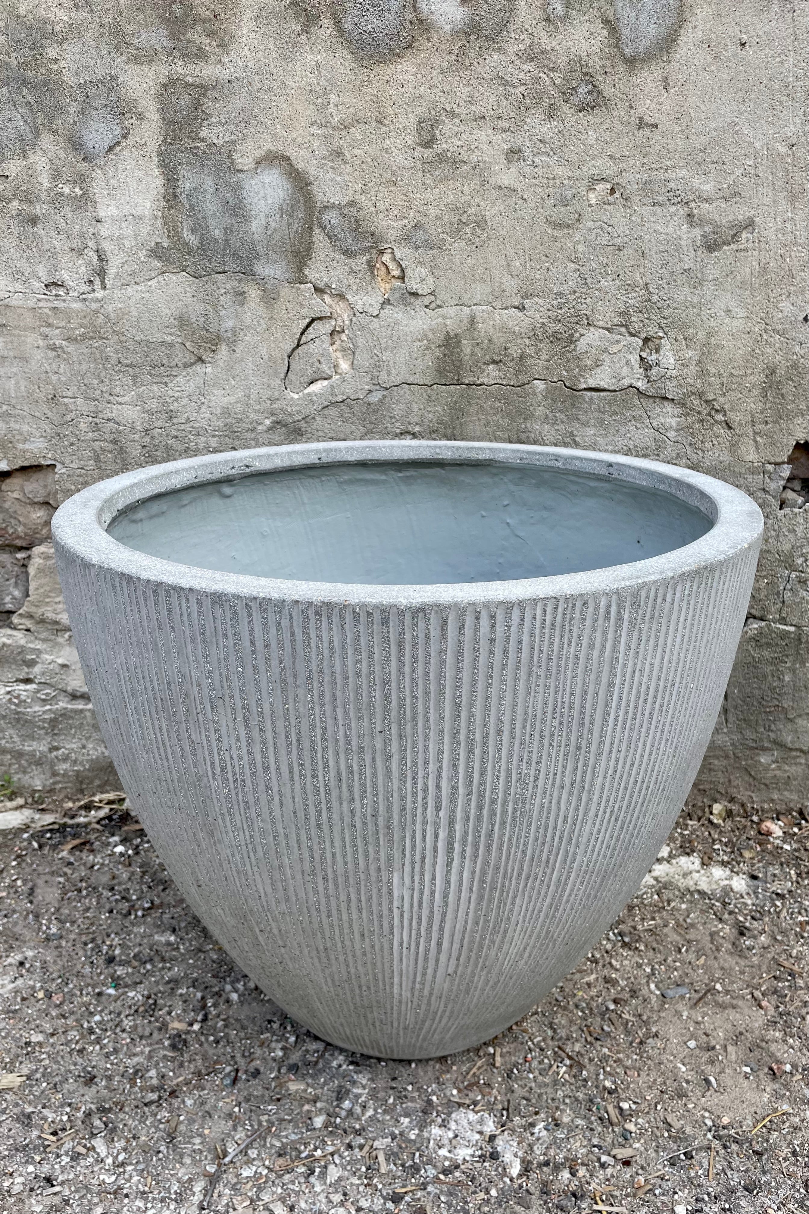 detail of Jesslyn Pot vertical ridged light grey small against a grey wall