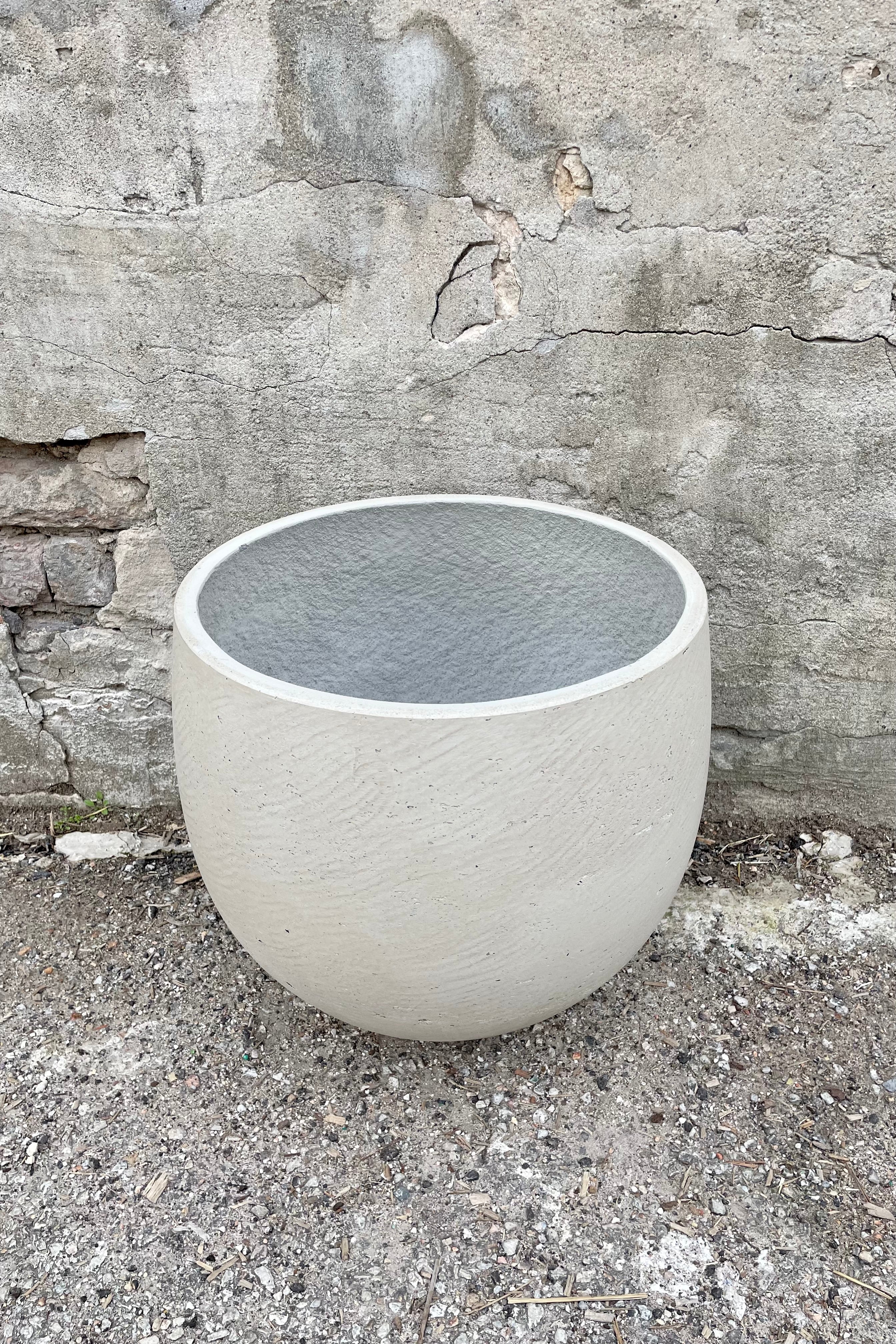 Detail of the top of the Mini Orb Pot Grey Washed Extra Large against a grey wall