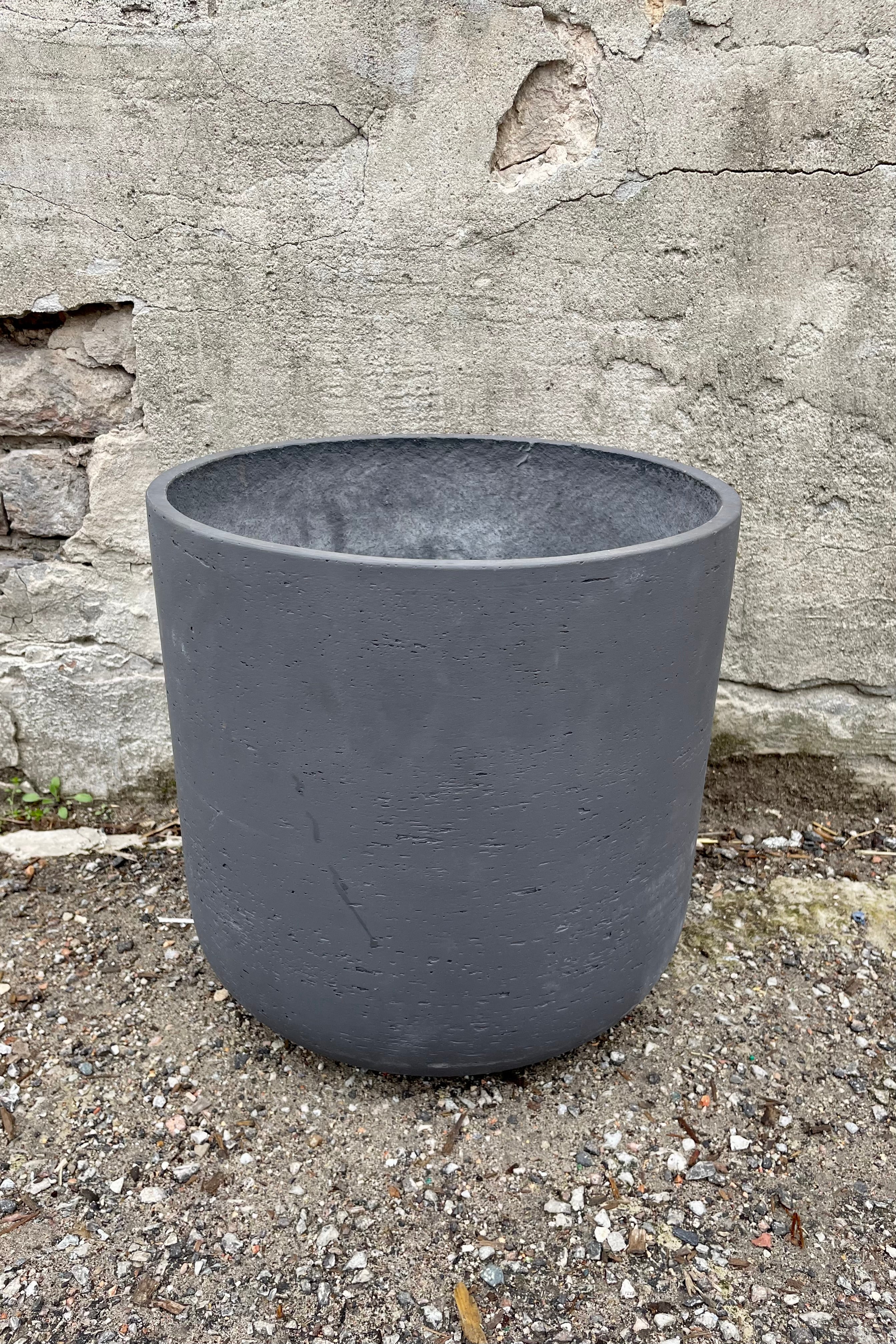 Detail of Charlie Pot black washed extra large against a grey wall