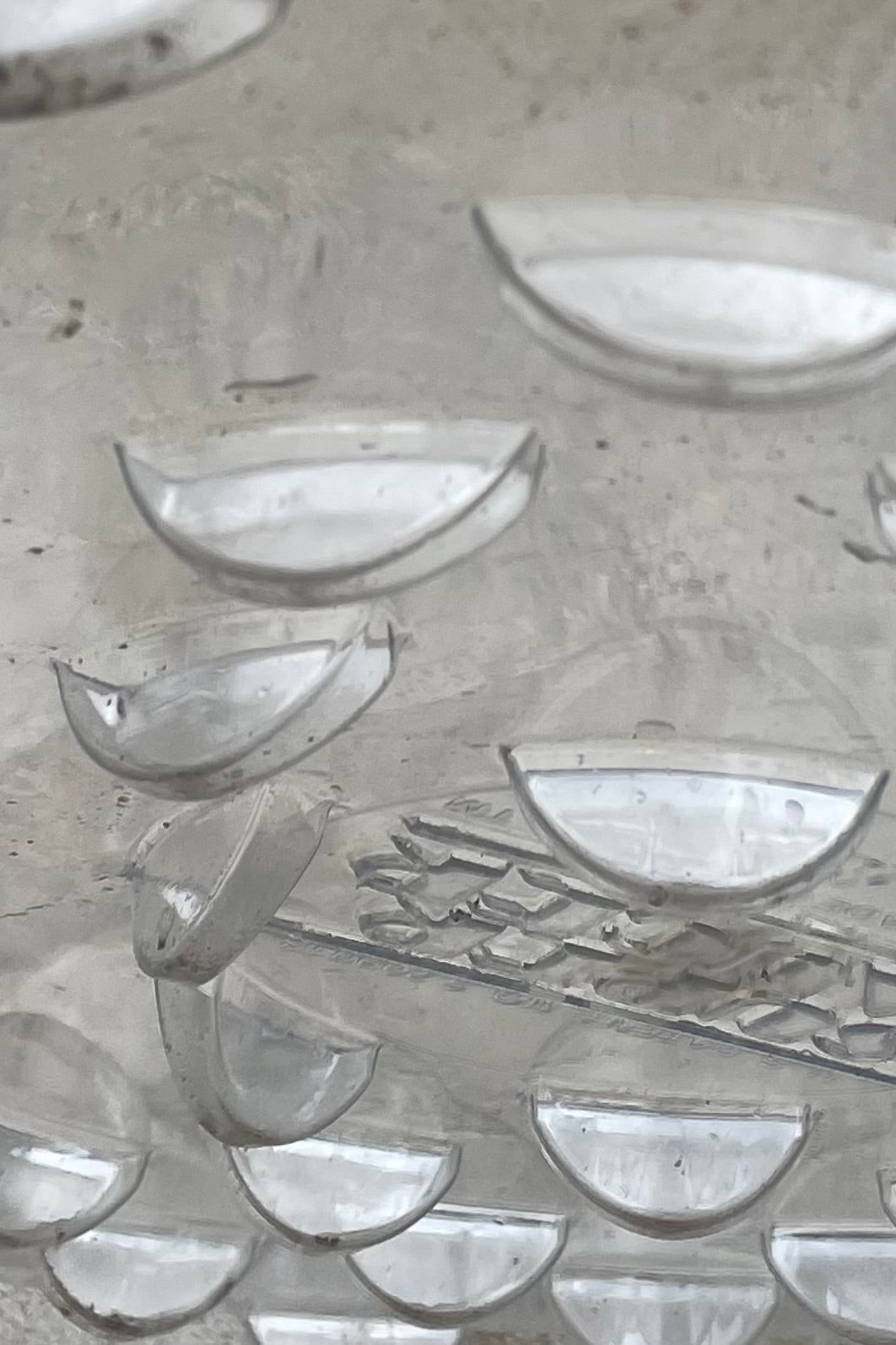A detailed view of the bottom ridges on Plastic saucer 20" against concrete backdrop