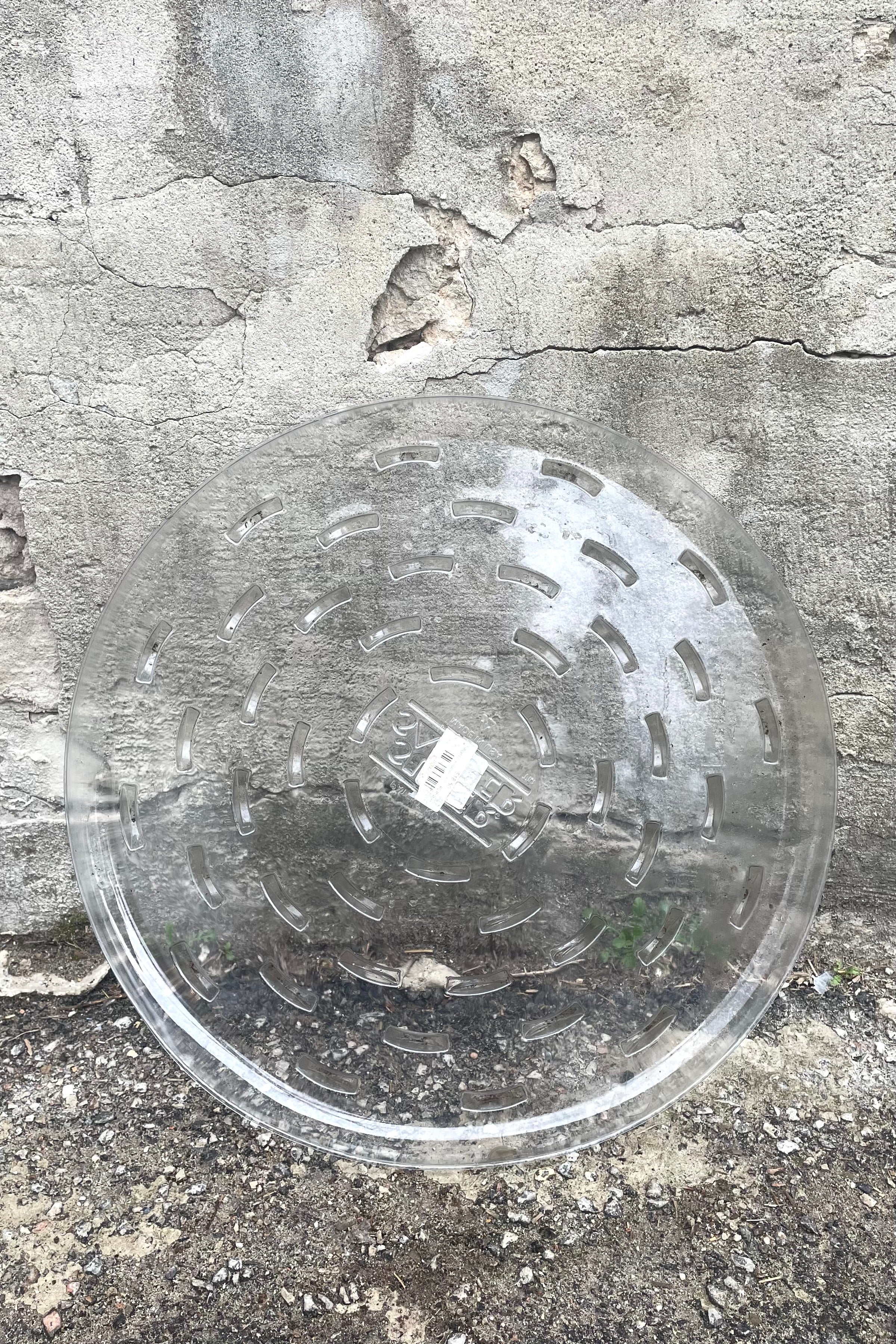 A full view of Plastic saucer 20" against concrete backdrop