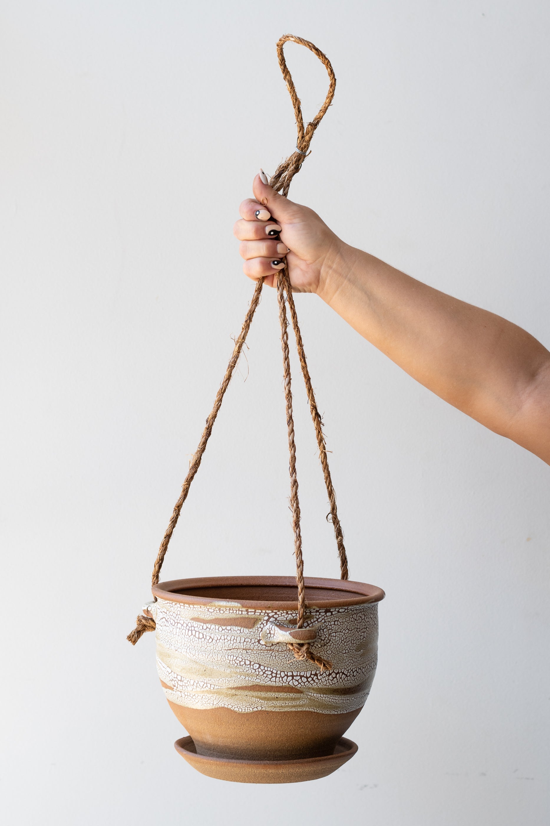 Bruning Pottery Hanging Planter super crackle glaze - 8" held in front of white wall