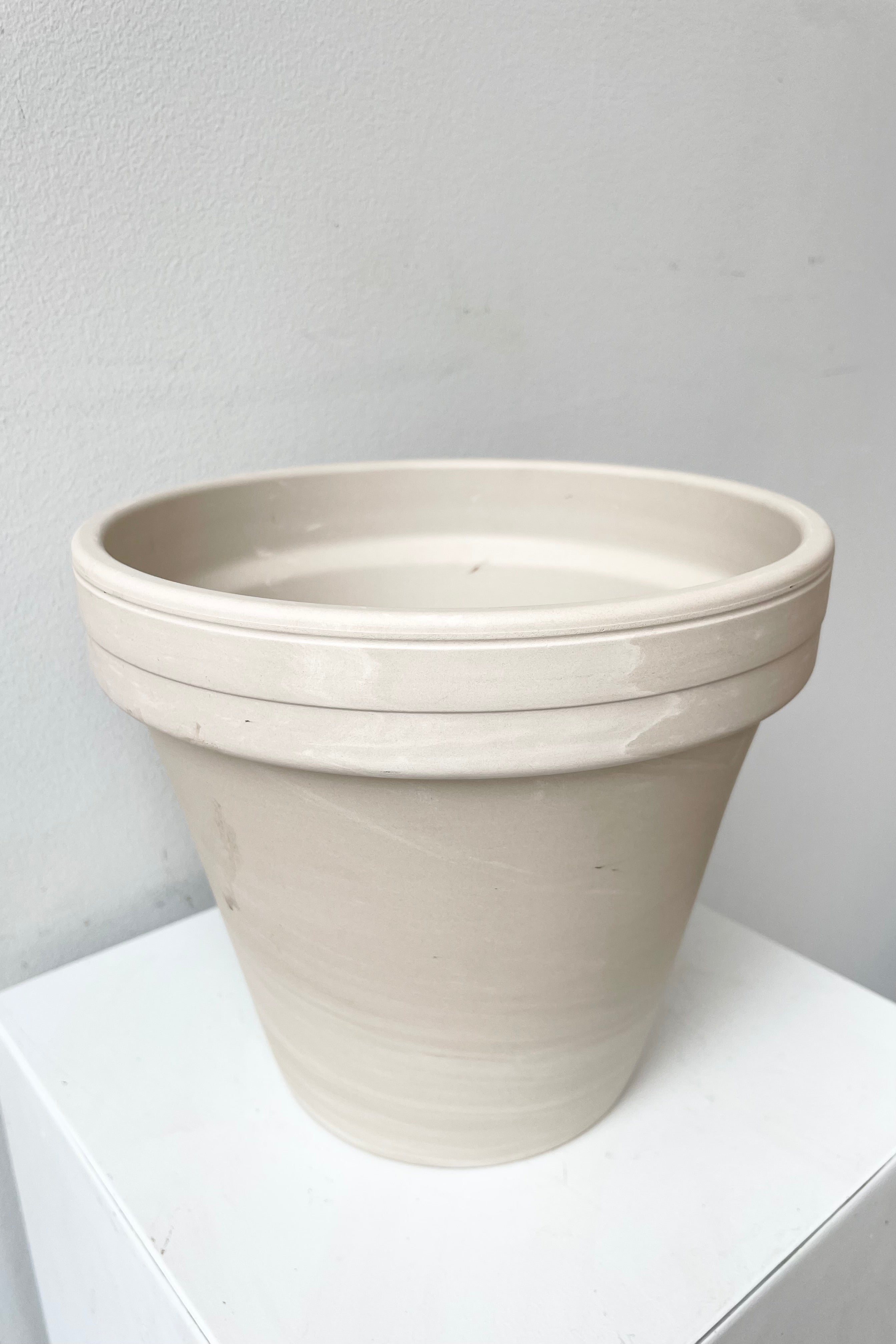 detail of the top pf Clay Pot granite 8" against a white wall