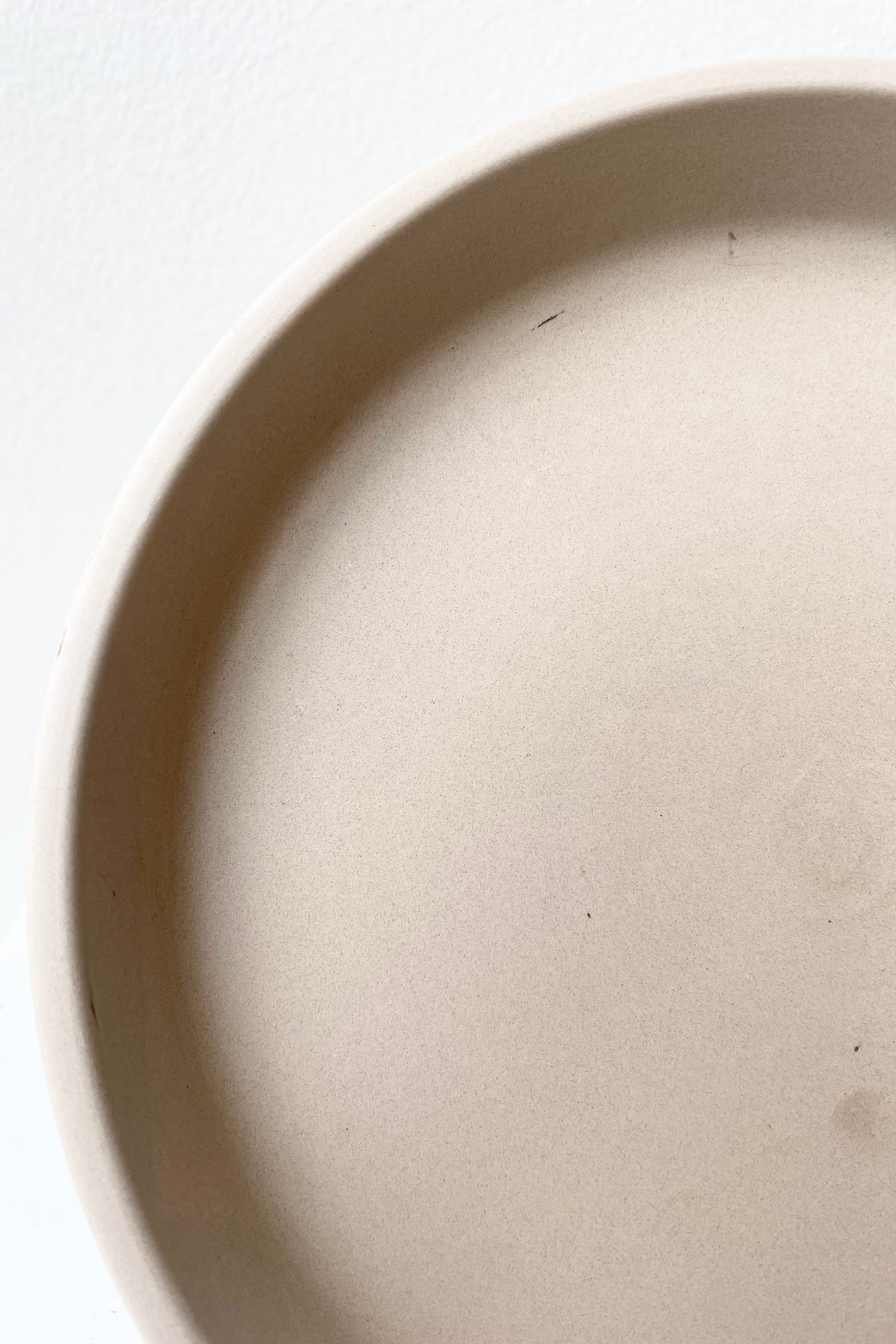 detail of Clay Saucer granite to fit 8" against a white wall